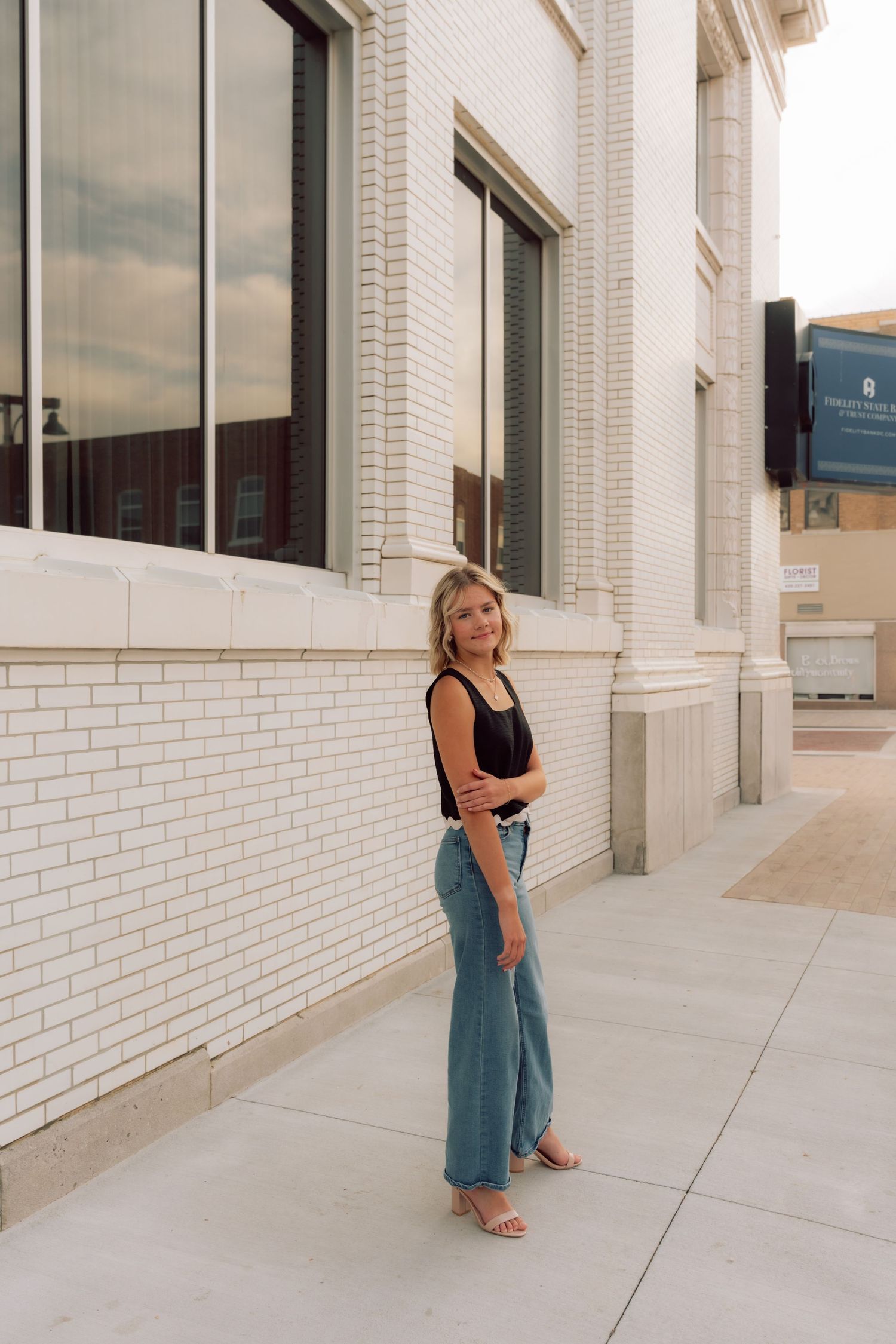 Street style photography series featuring denim and black top against urban architecture.