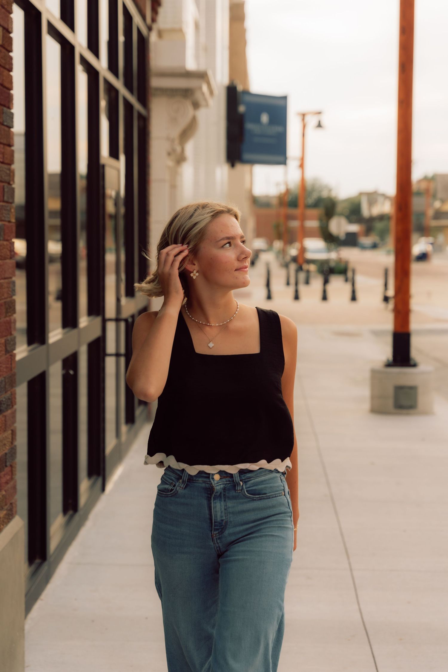Urban portrait session along a modern building exterior with architectural columns.