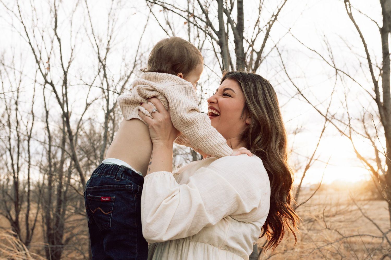 Family portrait session in wooded area during golden hour.
