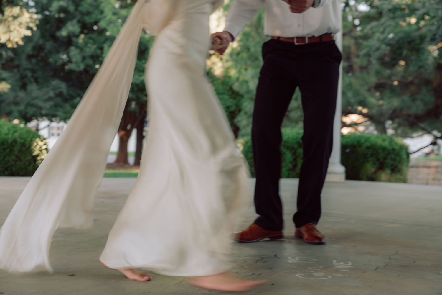 A flowing white dress twirls during a romantic dance in a gazebo.