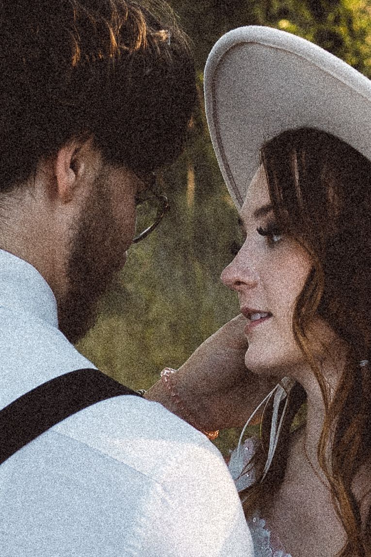 Close-up of a tender moment between a couple in wedding attire at sunset.