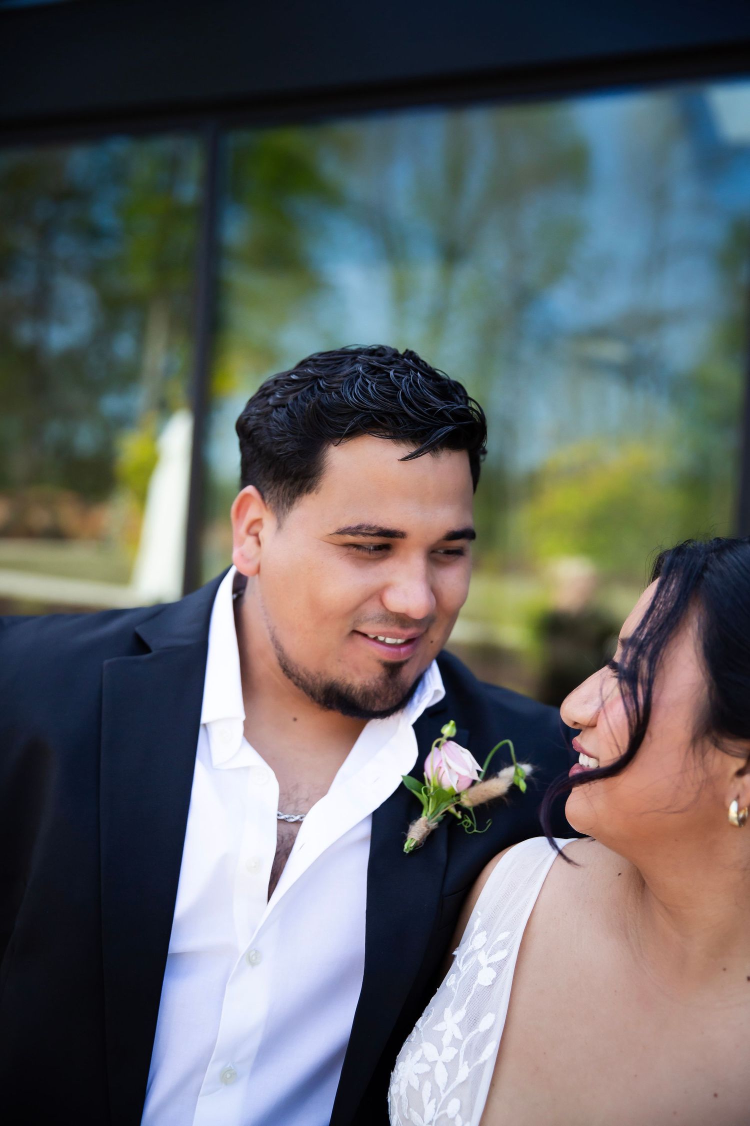 Wedding Scene with Groom looking into bride's eyes as she coyfully pulls away