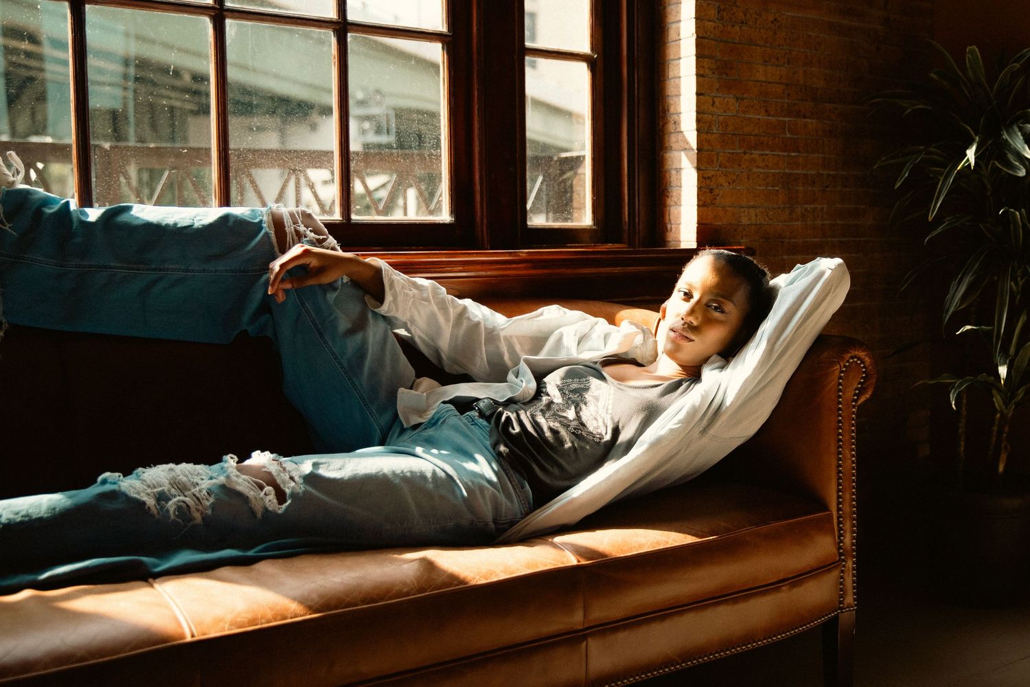female model lounging in leather chair