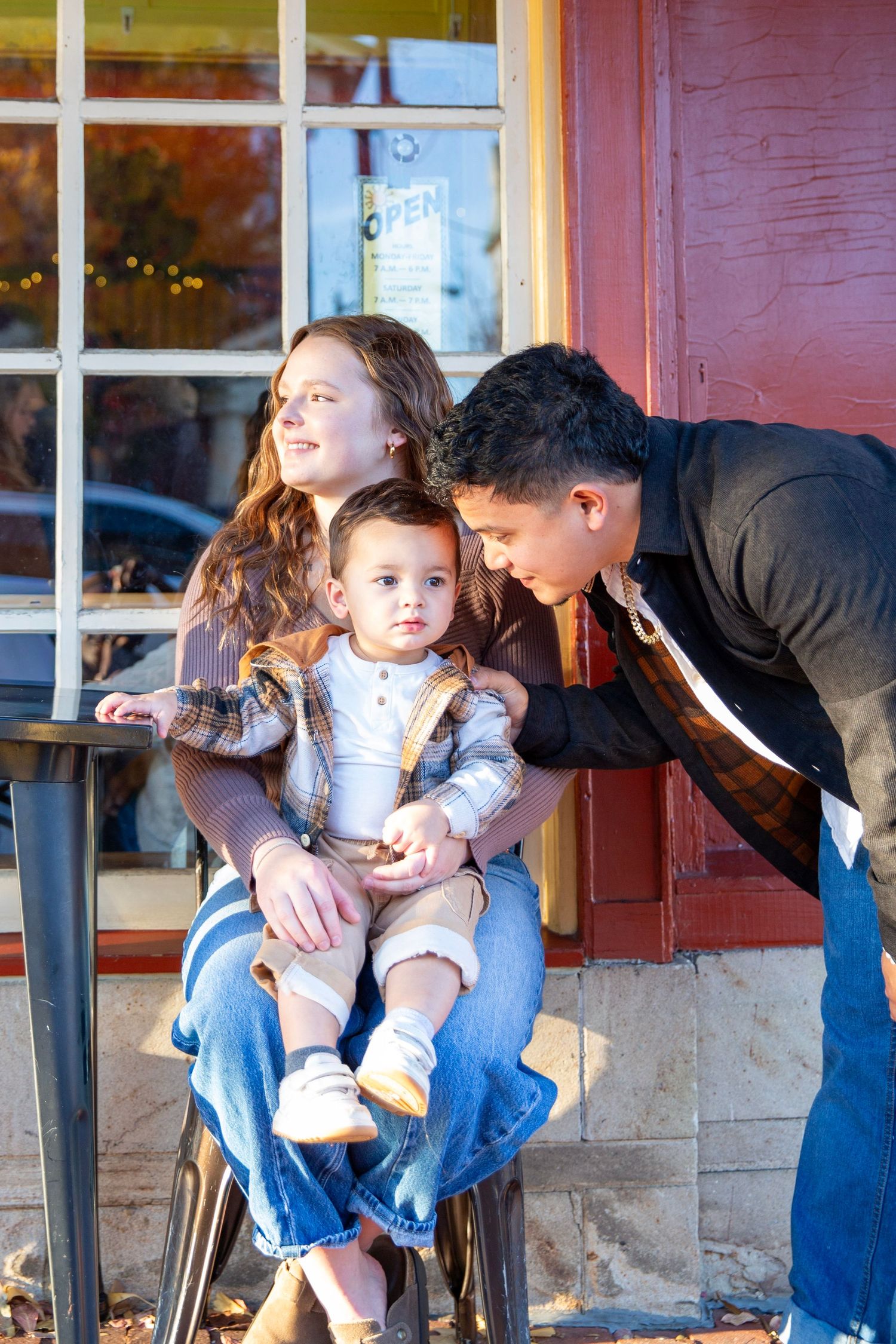 Family  of three sharing a moment in front of a cafe