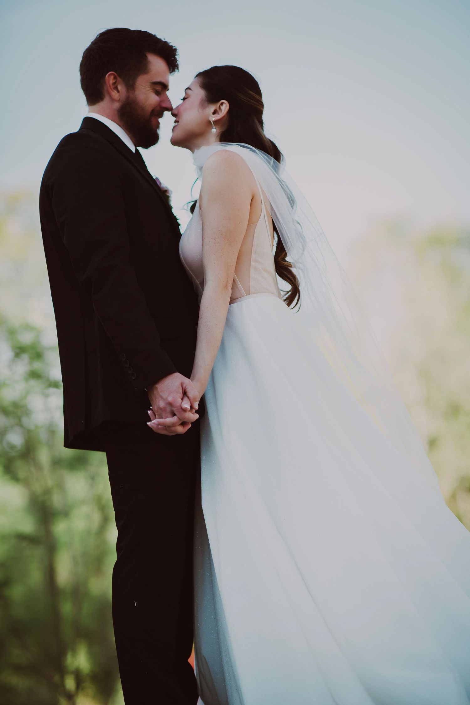 Bride and groom touching noses and laughing
