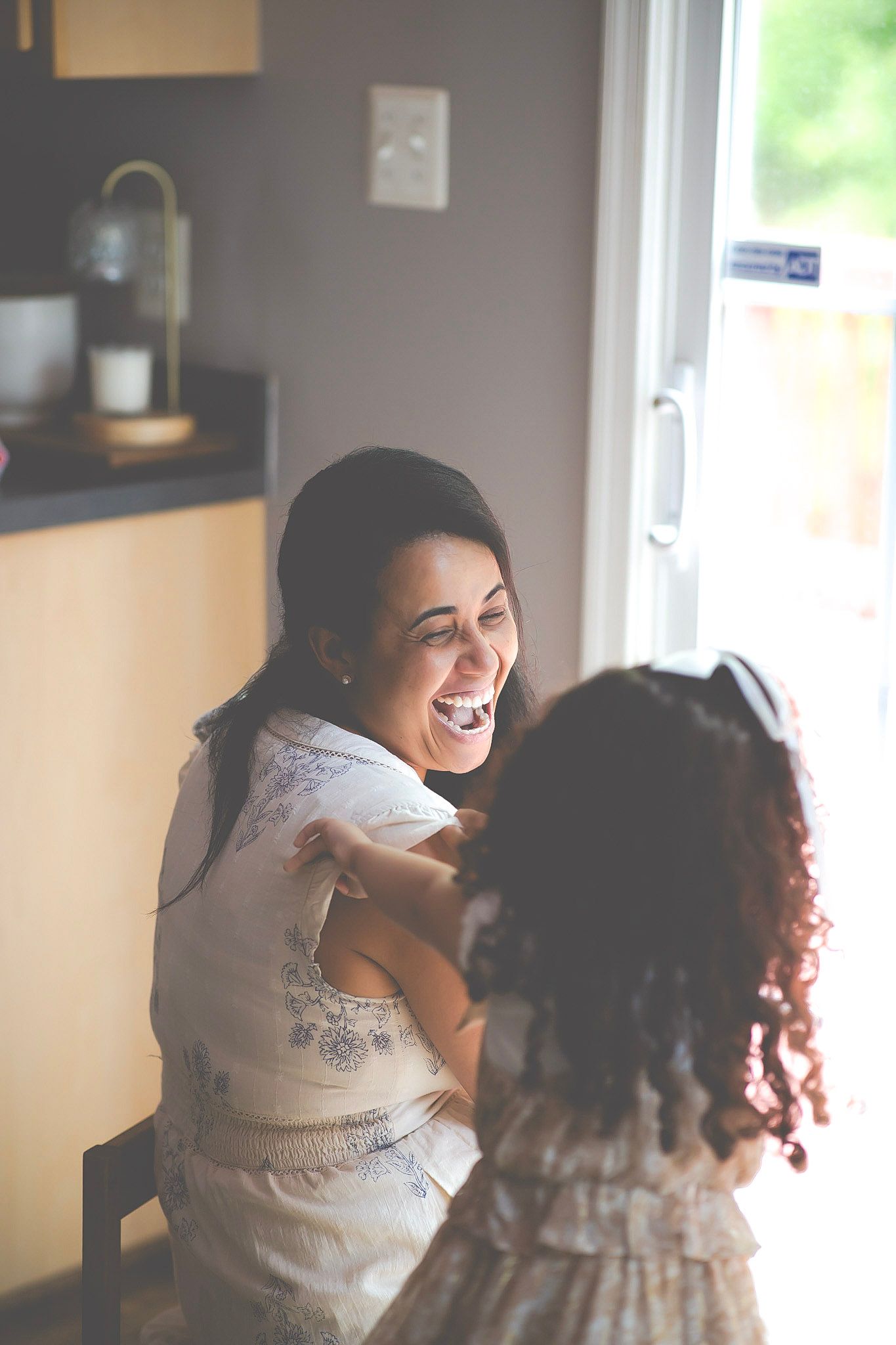 Mom laughing with her little girl