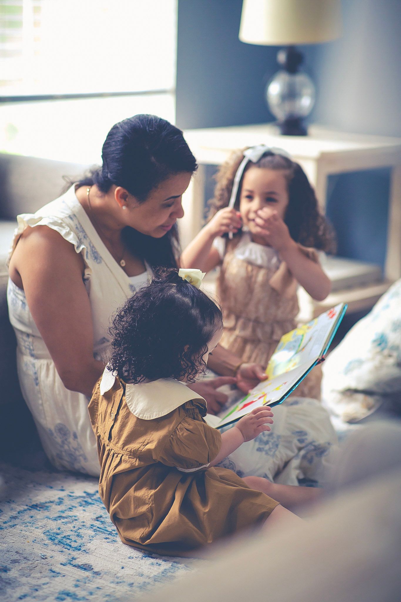 Mom and daughters huddle over a book