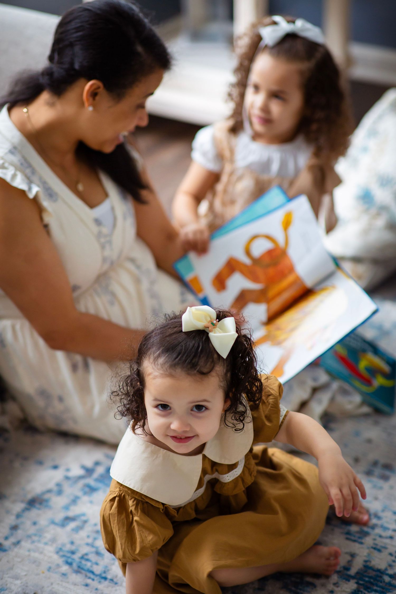 Mom and daughters huddle over a book