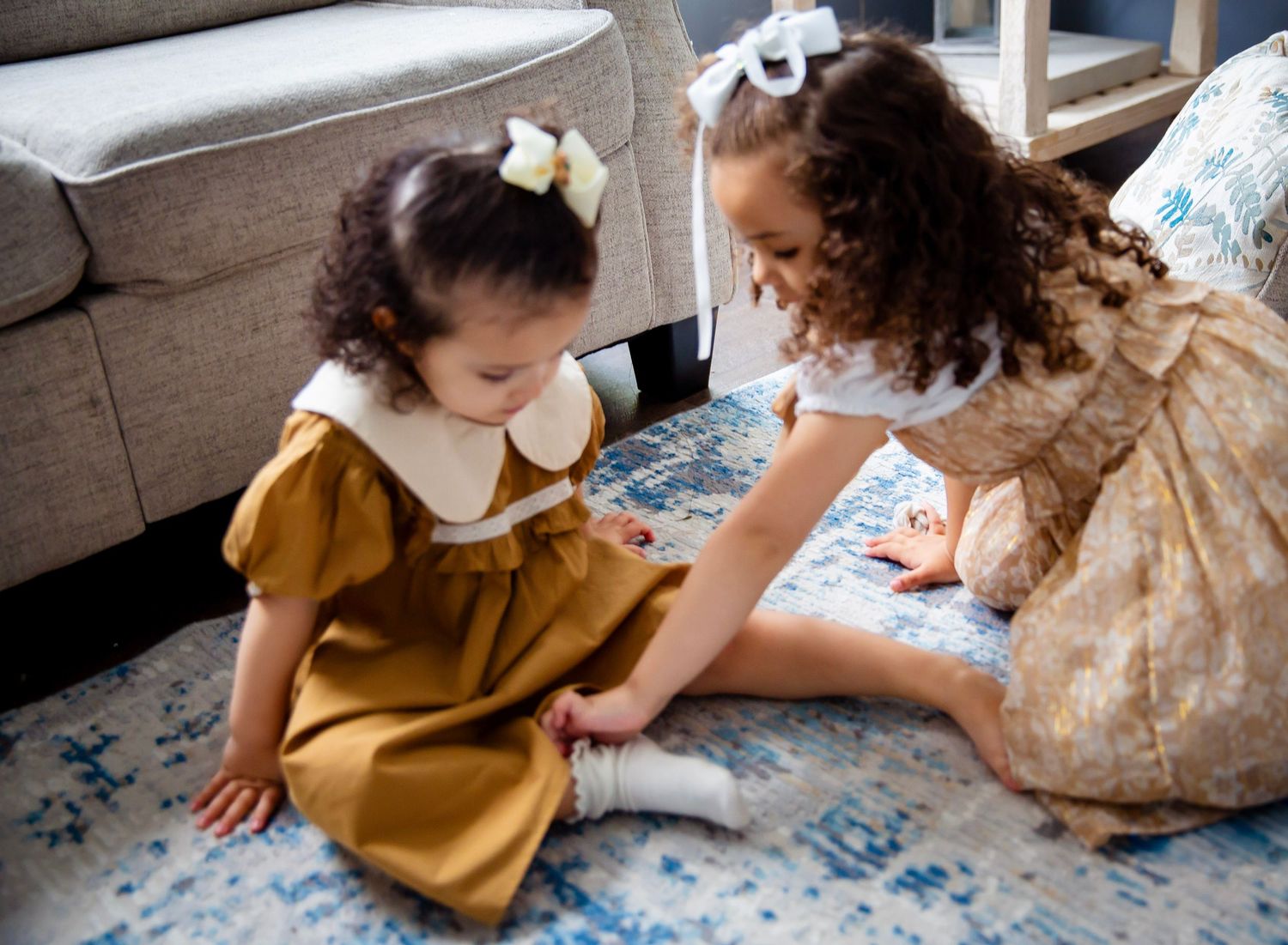 Little girl helps her sister with her socks