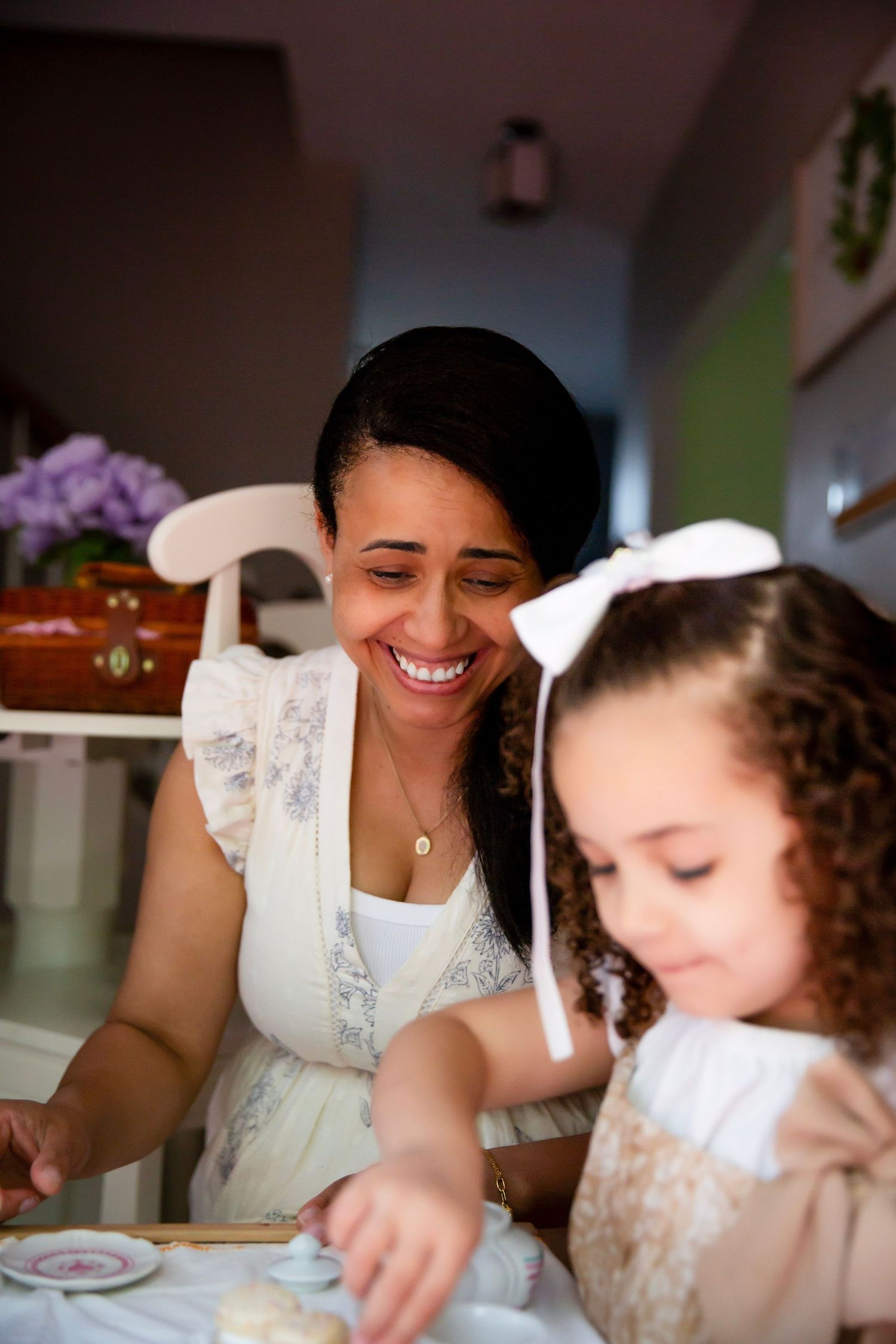 Mom helping toddler girl at a tea party
