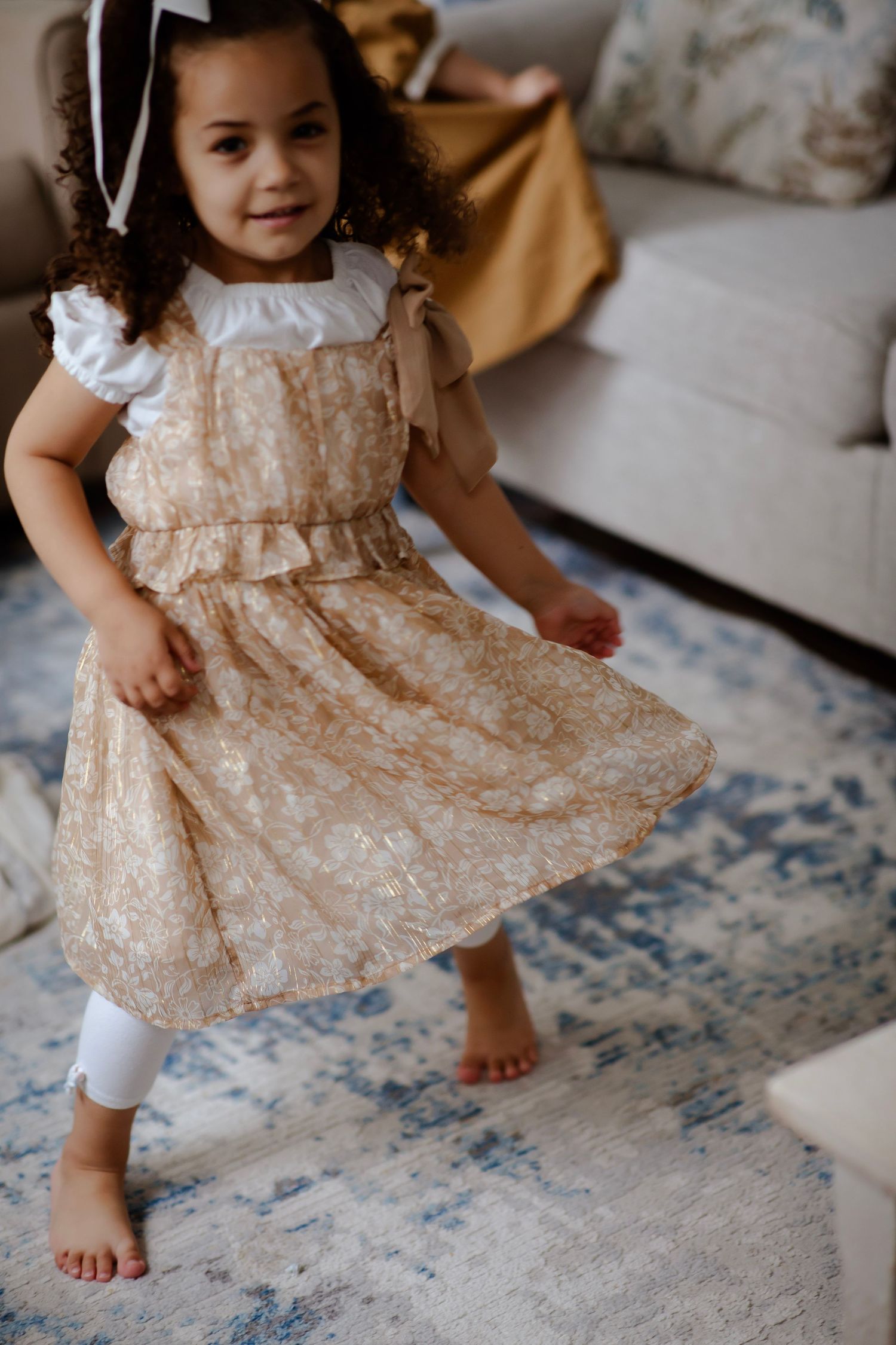 Two little sisters twirling in their dresses.