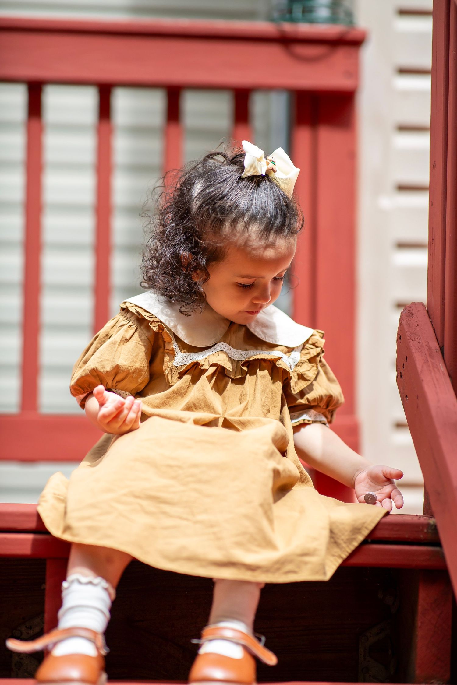 Toddler girl on steps in vintage outfit