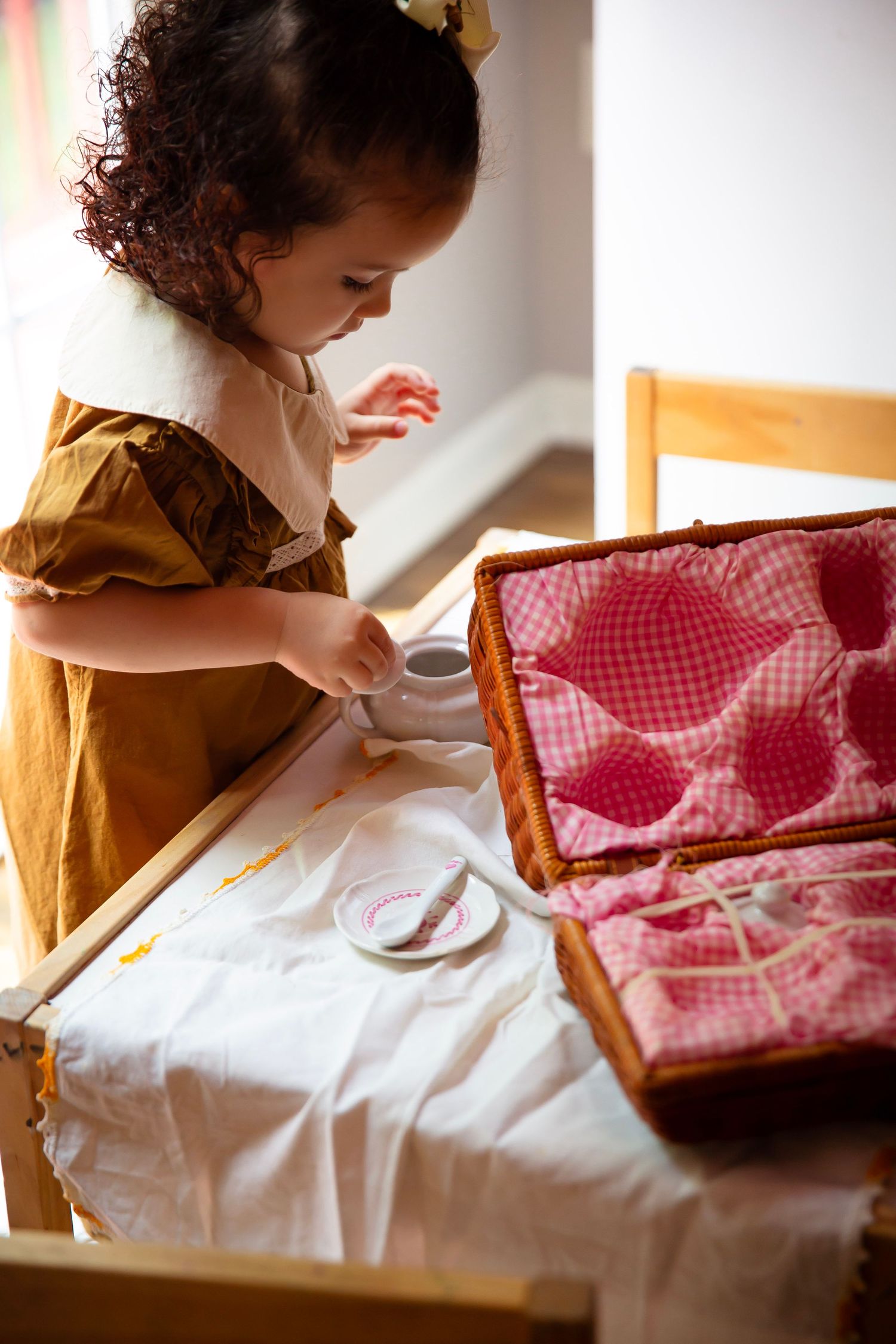 Toddler girl with play tea set