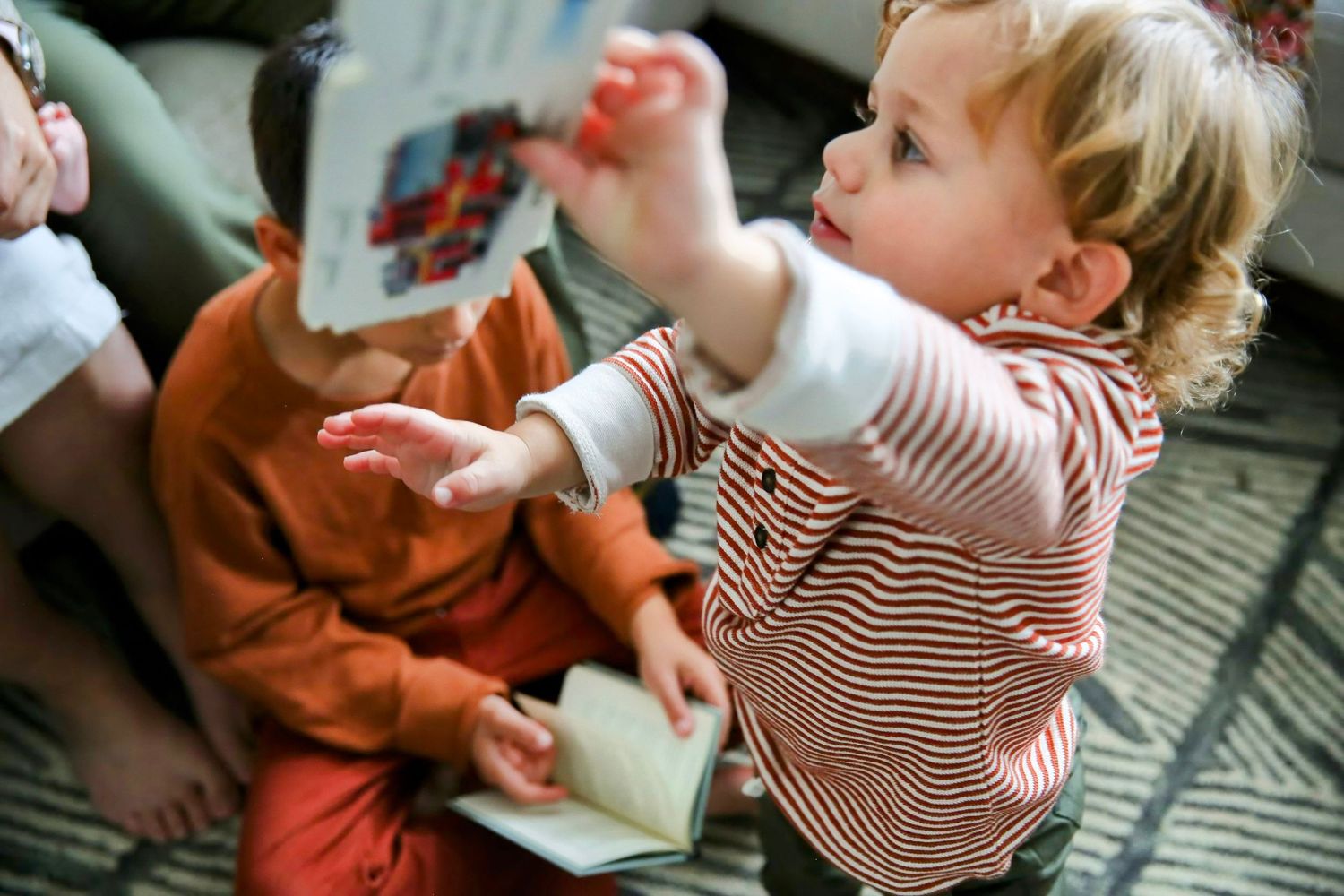 Toddler boy, fun with siblings, sharing book