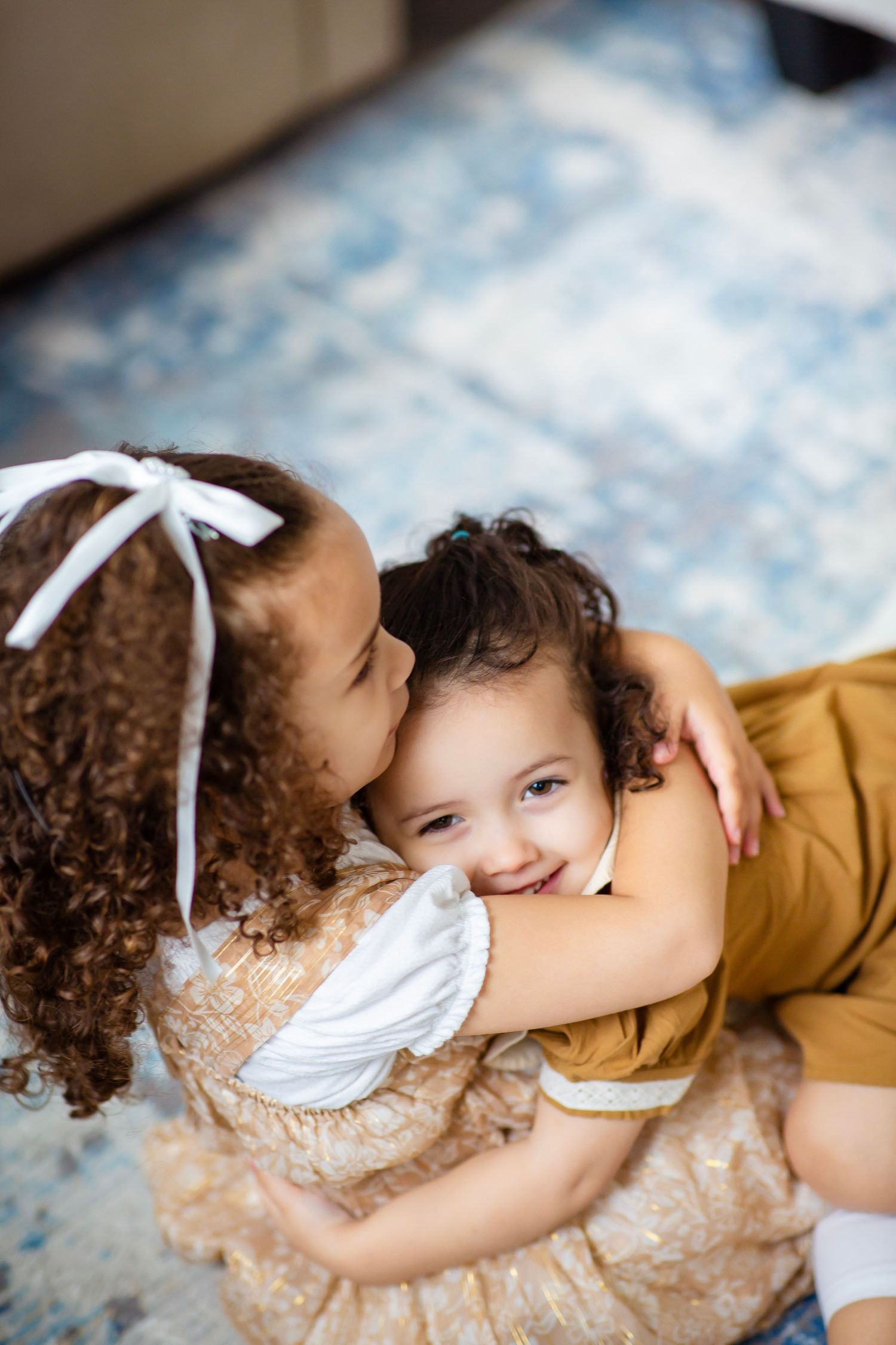 Two young sisters laughing and hugging