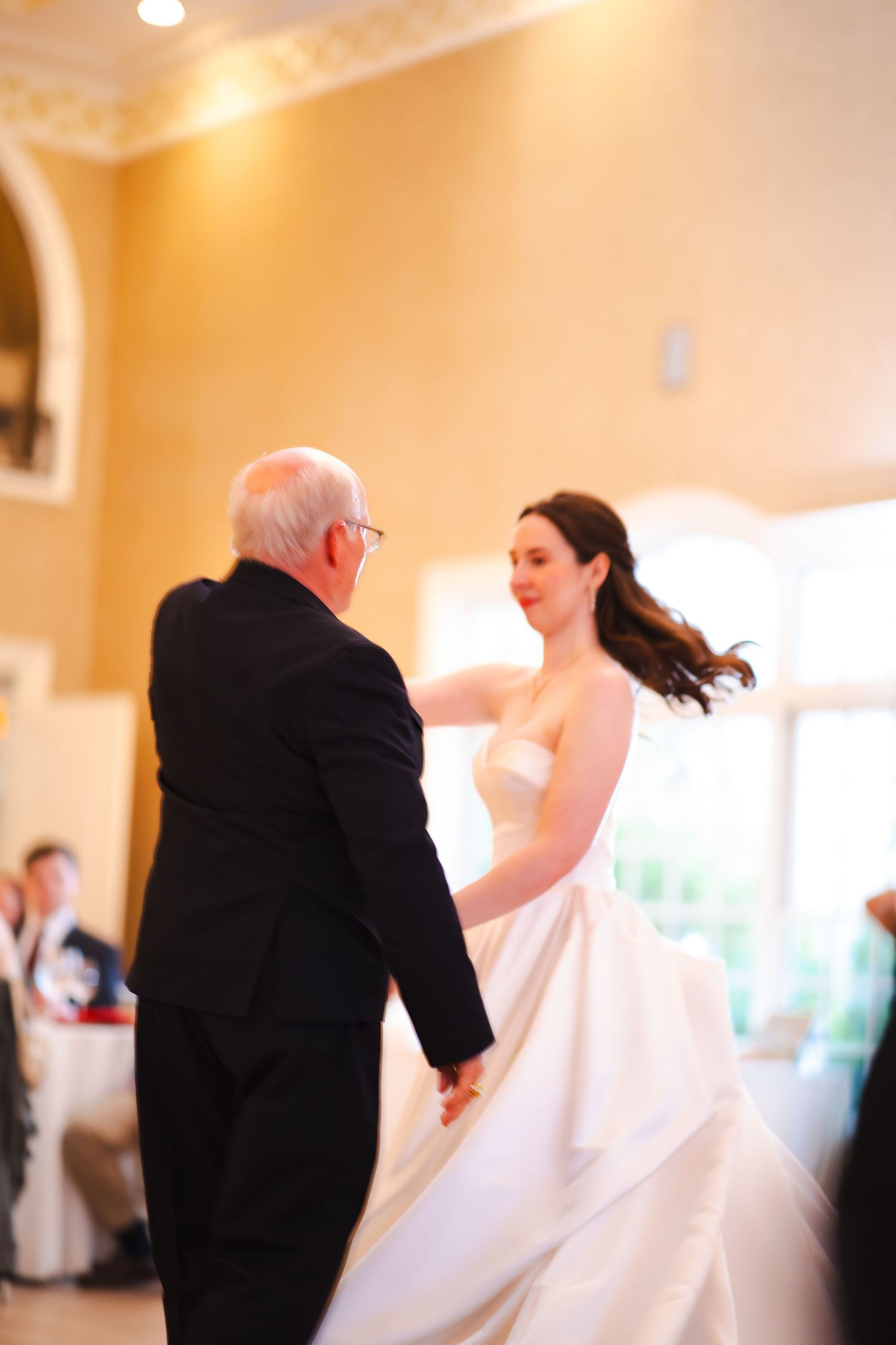 Bride shares an emotional father-daughter dance at elegant wedding reception.