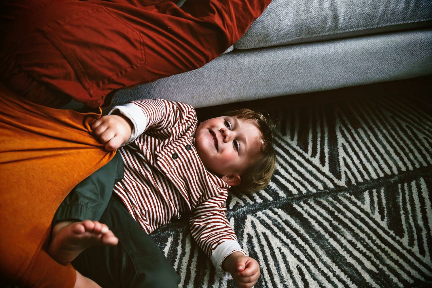 Toddler boy on floor playing with siblings