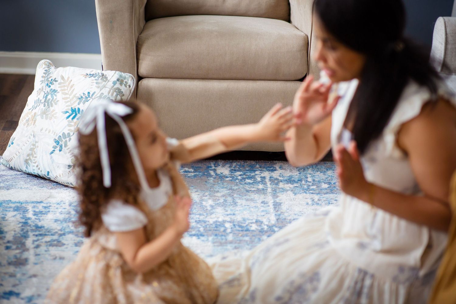 Mom playing hand games with young daughter