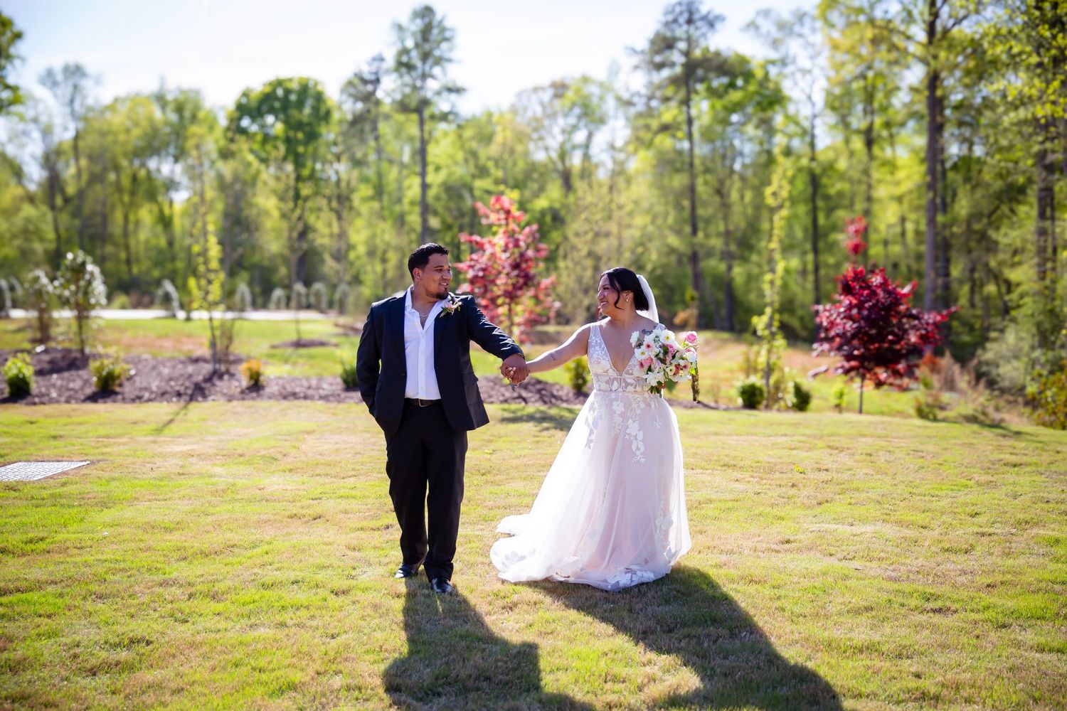 Bride and groom holding hands and walking toward the camera.