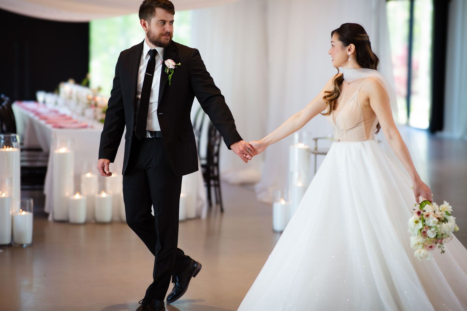 Groom gently leading bride along a room