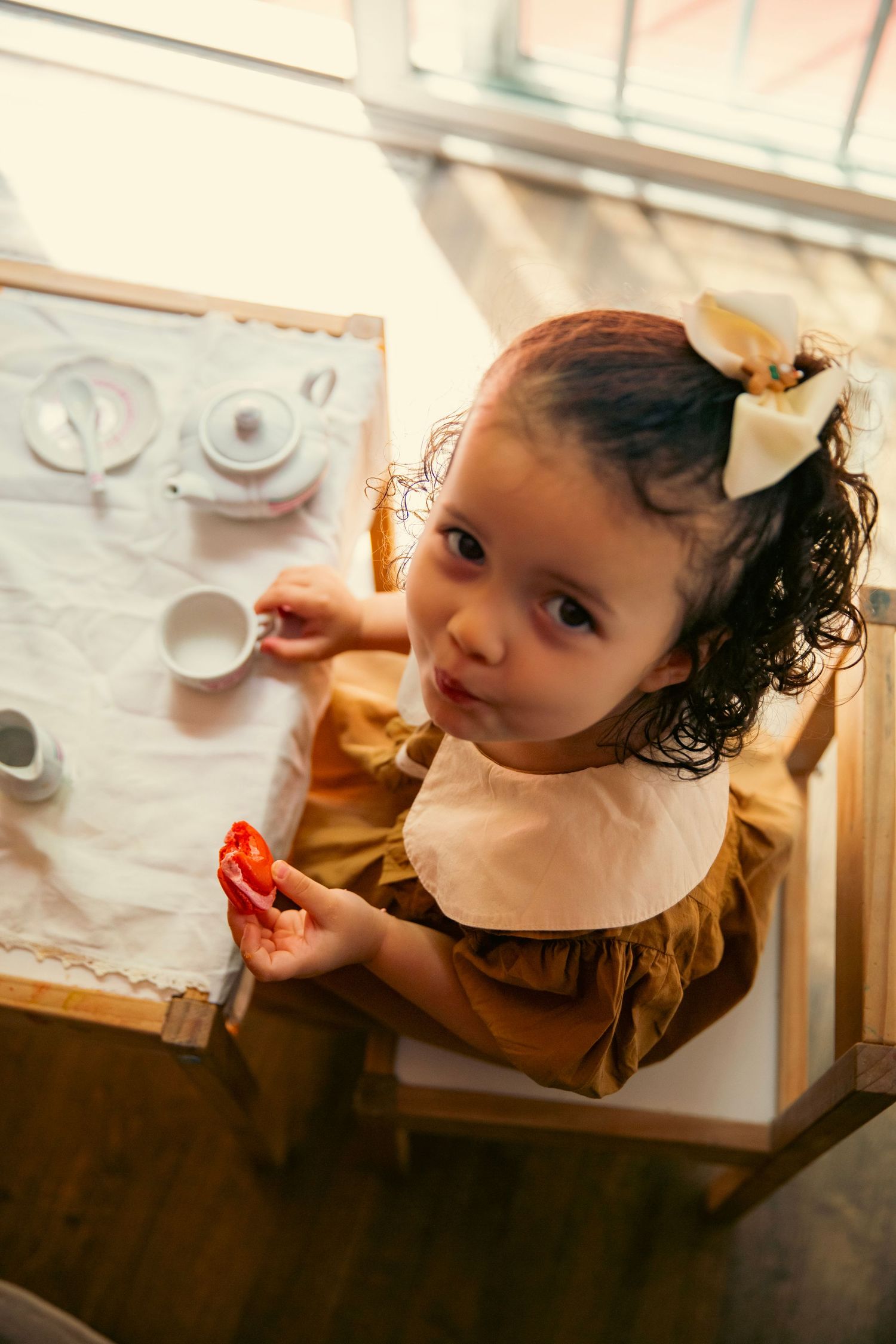 Toddler girl eating macarons at a tea party