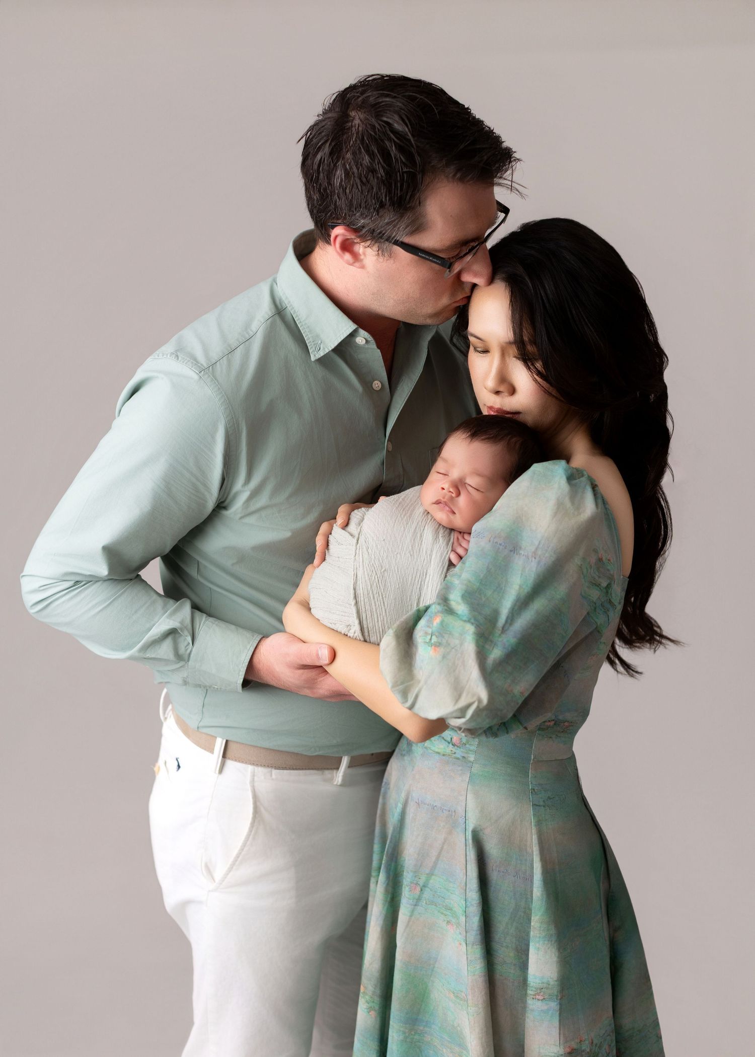 Parents holding their newborn baby in a soft studio portrait, family newborn photography in Vacaville California