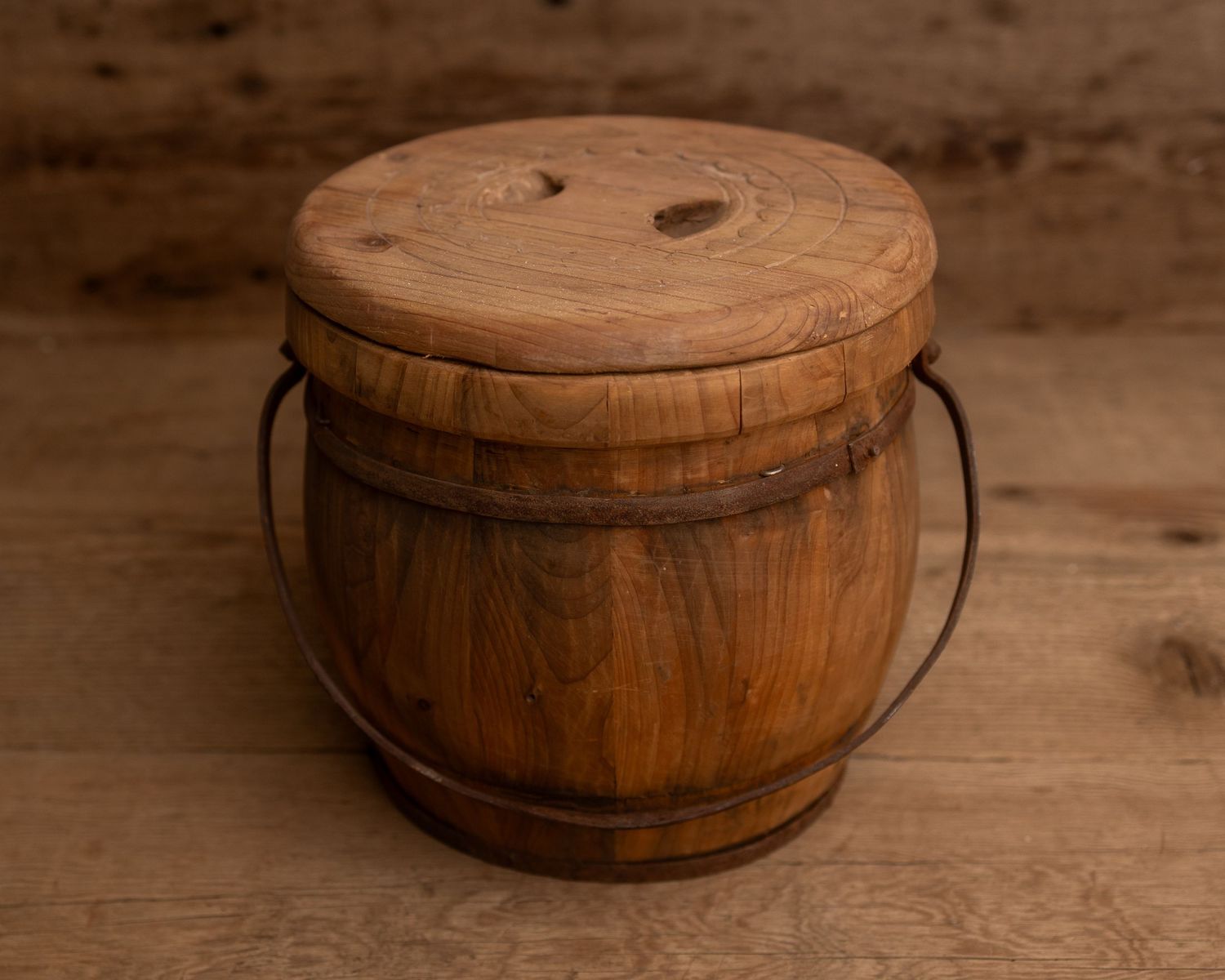 Rustic wooden barrel bucket with metal handle and round lid, crafted from aged teak wood, perfect for vintage decor.