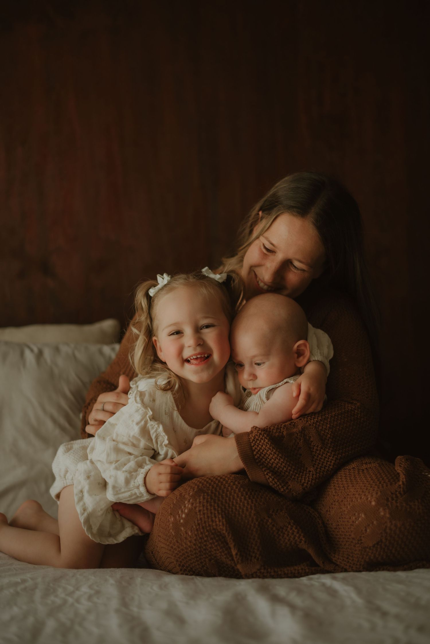 Gentle newborn photography in Tasmania, captured in a rustic barn studio with natural light, focusing on soft, calm and connected family.