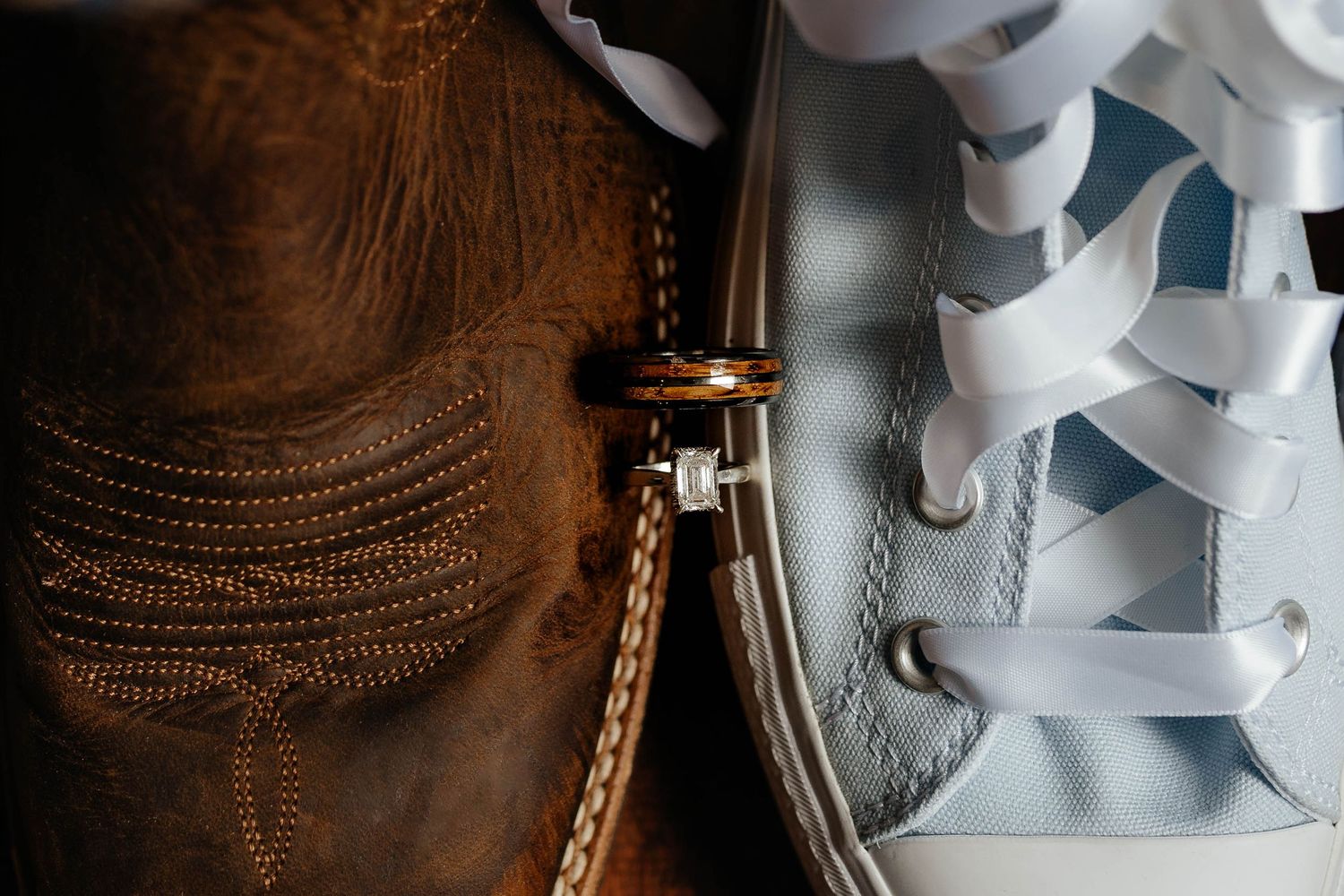 Gold wedding band and chain resting against embossed leather and white Converse sneaker laces.