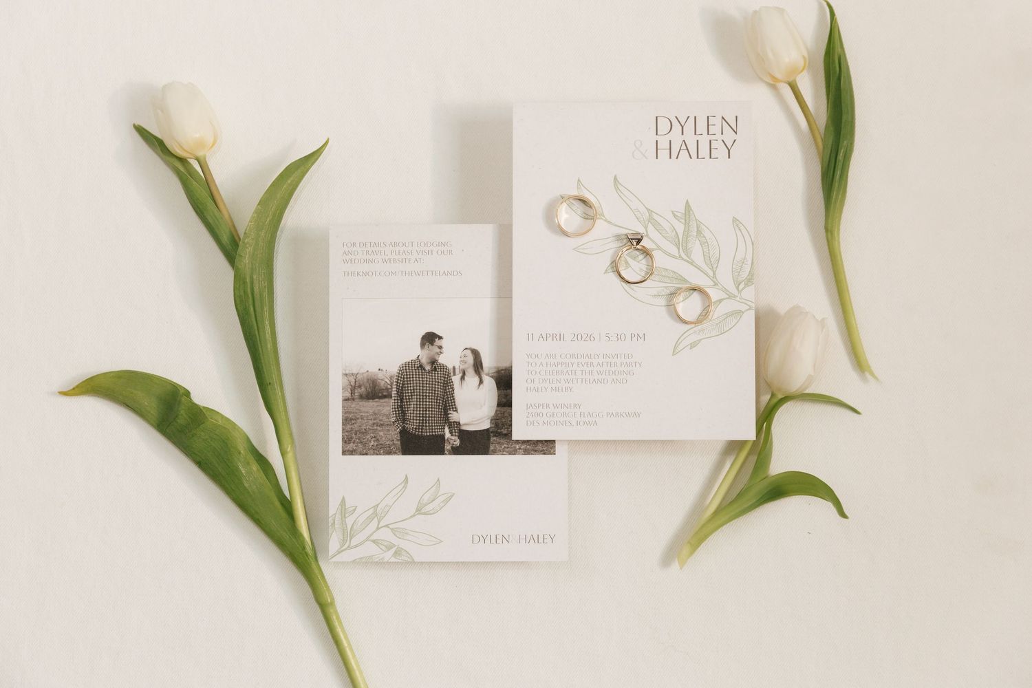 Elegant wedding invitation suite for Dylen and Haley with gold rings and white tulips on white background.