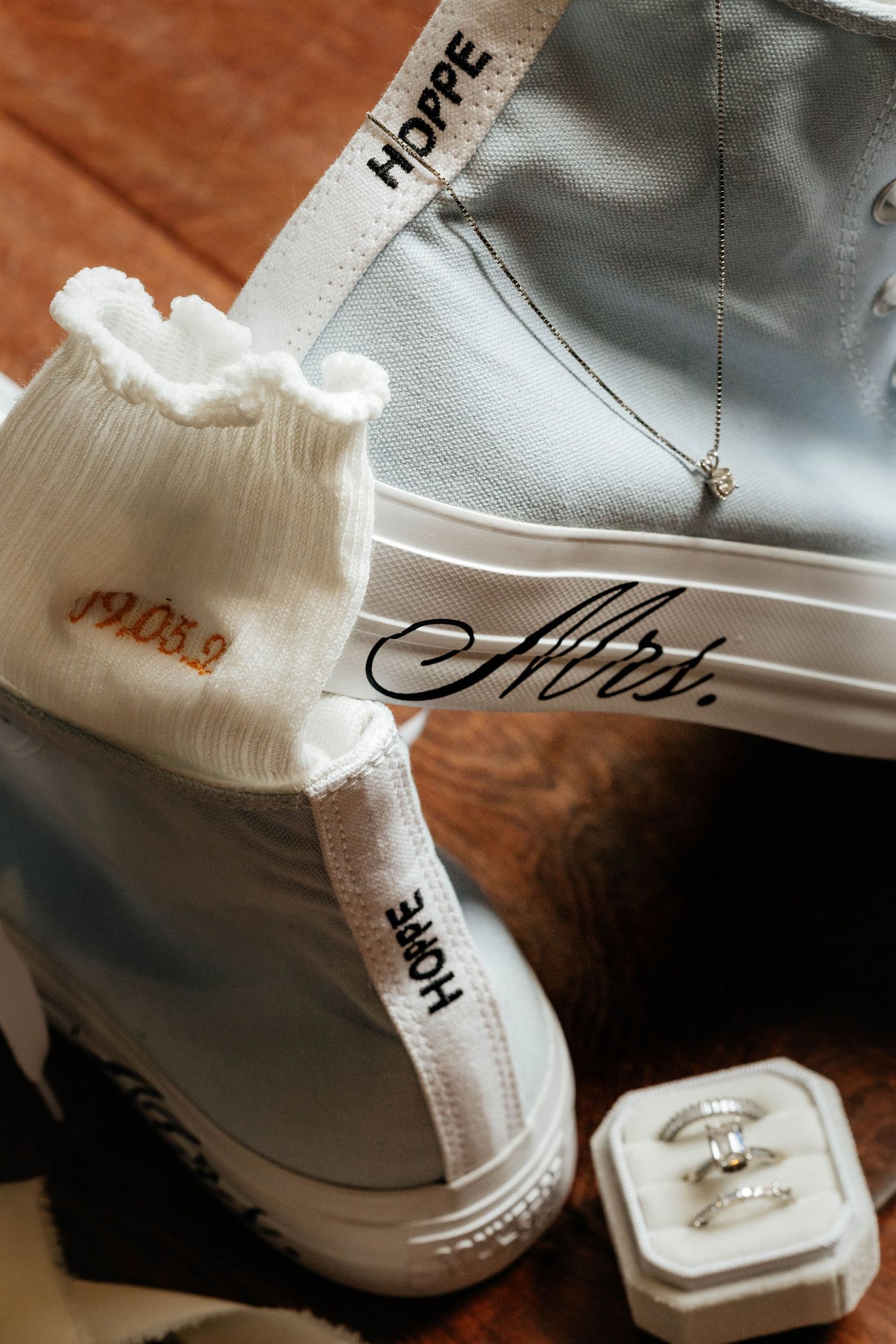 Custom Mrs. Hoppe white Converse wedding sneakers with dated socks and diamond ring set in box.