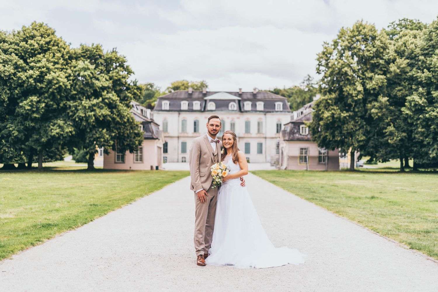 Hochzeitspaar vor einem Schloss
