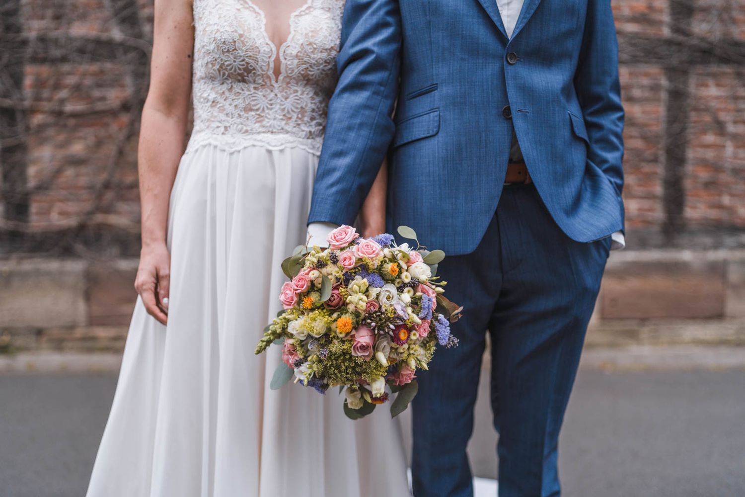 Hochzeitspaar mit Brautstrauß in der Hand