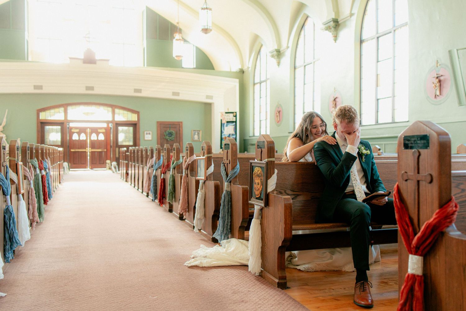 Bride and groom share a quiet intimate moment seated together in a beautiful historic church pew.