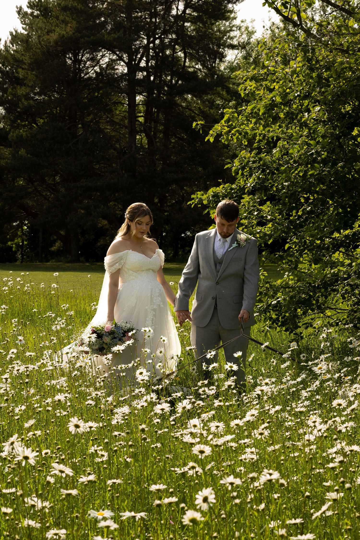 Bridge and groom walking through long flowers