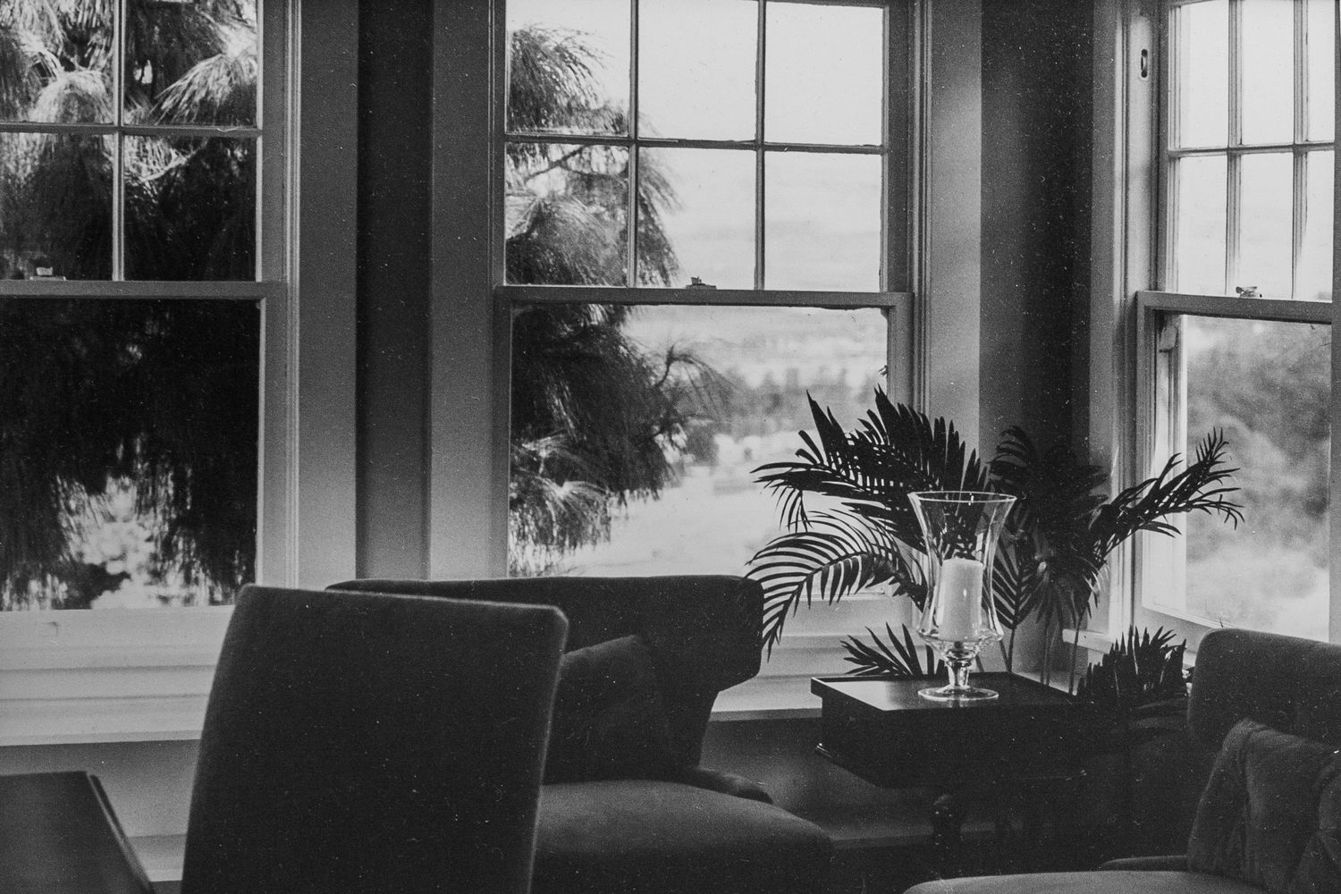 black and white silver gelatin print of a sitting room with multiple views through symmetric windows, San Diego, CA