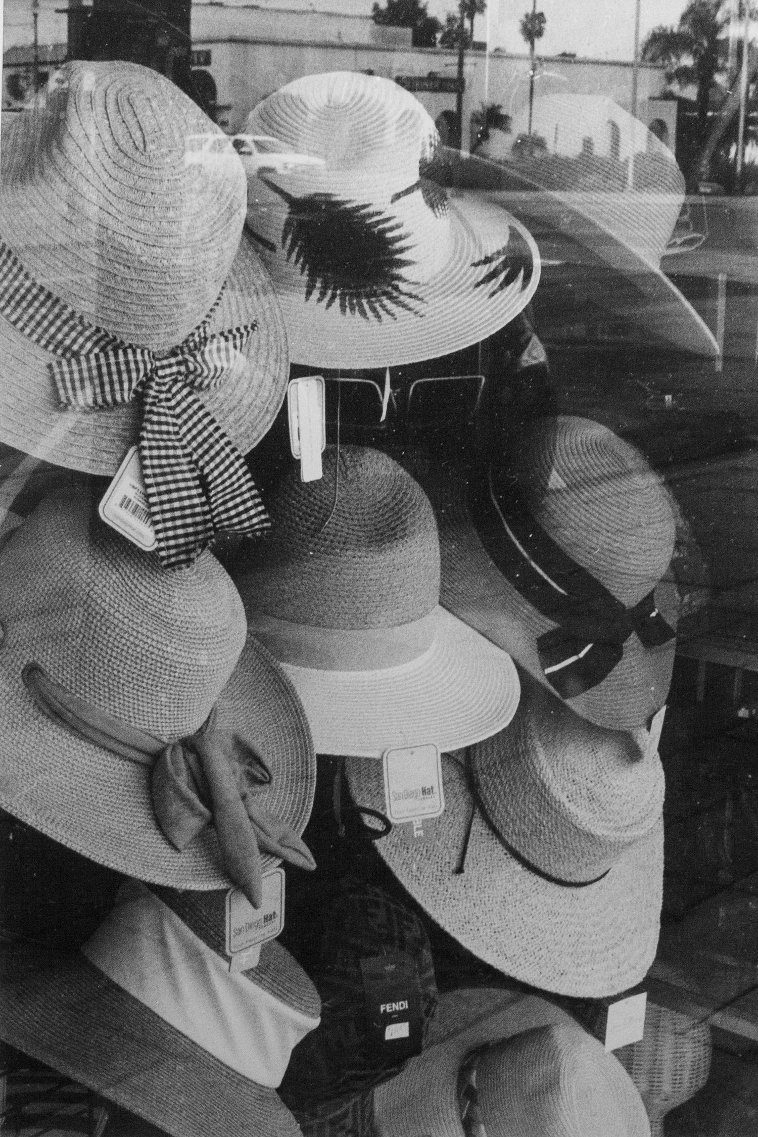 black and white silver gelatin print of hats on display in storefront window in Escondido, CA