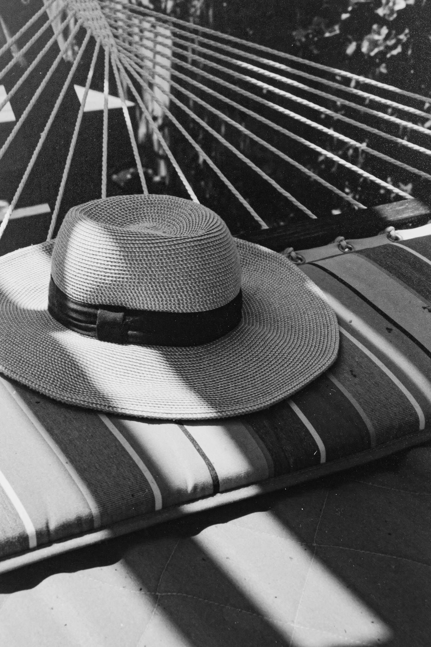 black and white silver gelatin print of a textured fabric hat resting on a hammock with circular and linear aspects captured
