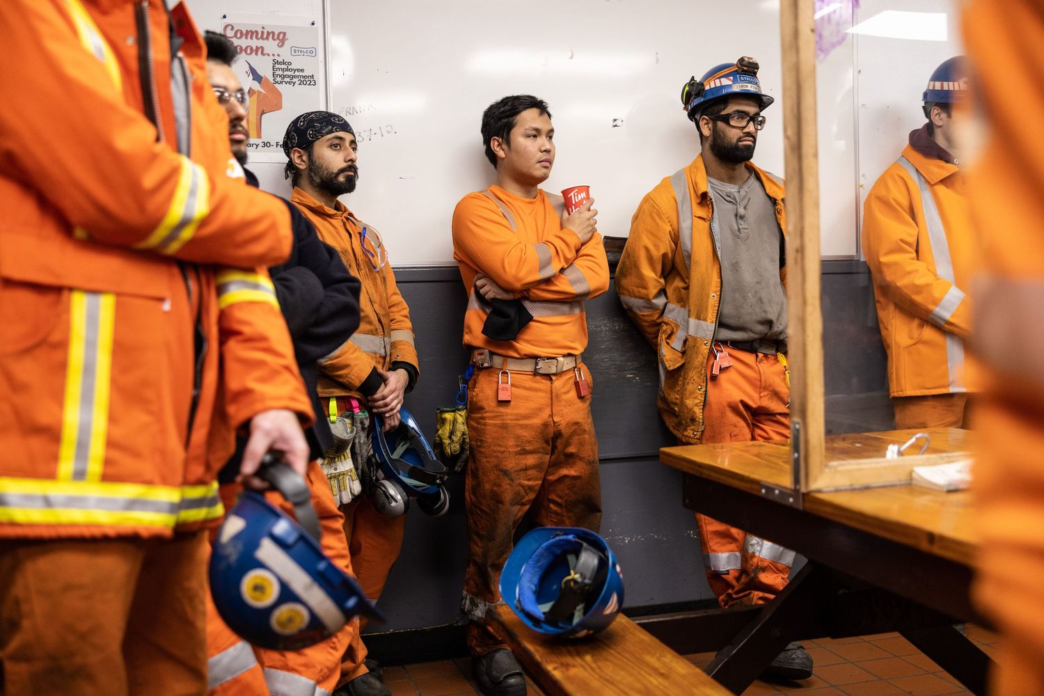 A group of construction workers applauds at an event for industrial construction documentary photography