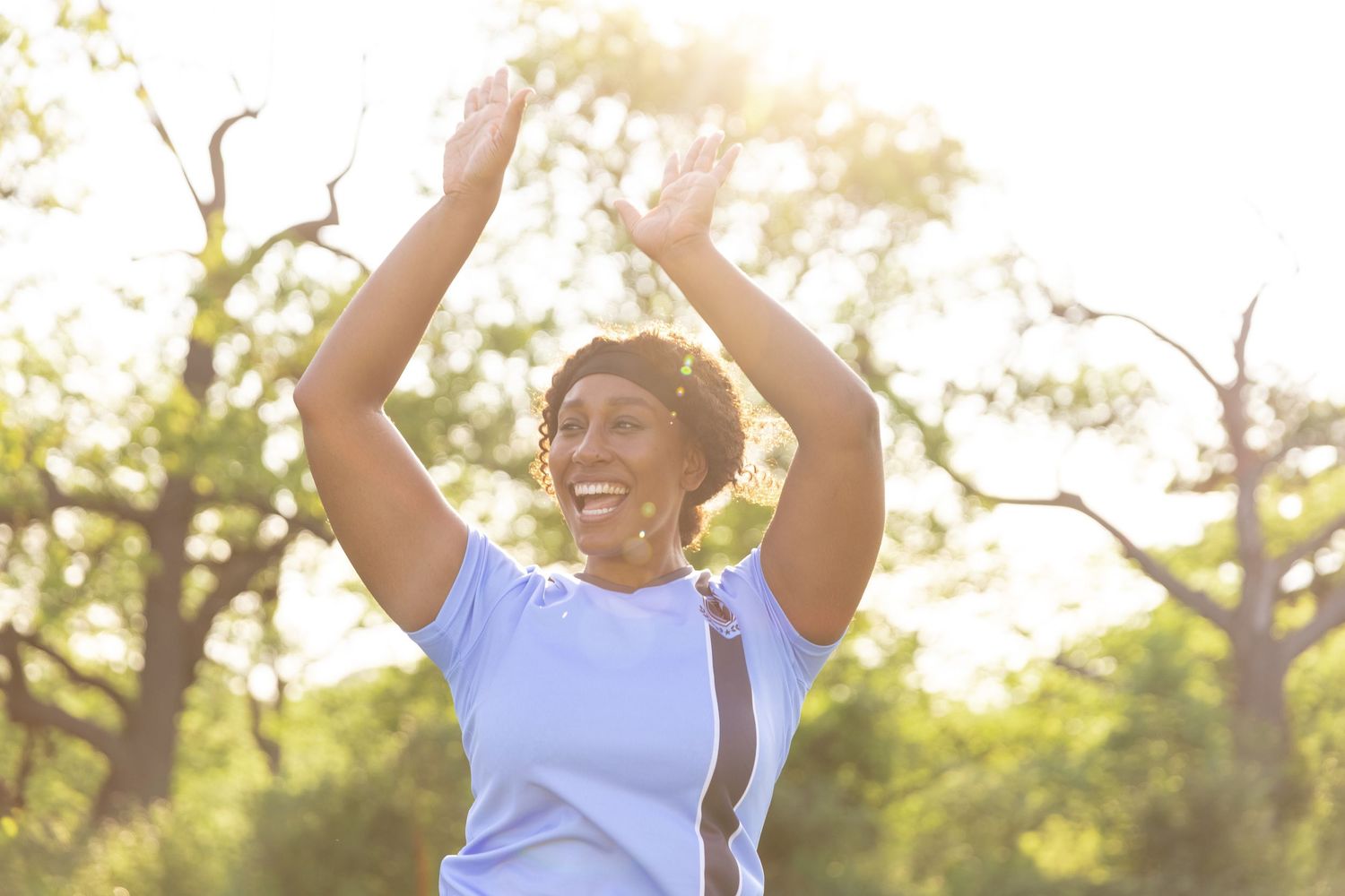 A young black woman smiles while playing sports outdoors. Commercial lifestyle photography, summer, canadian tire.