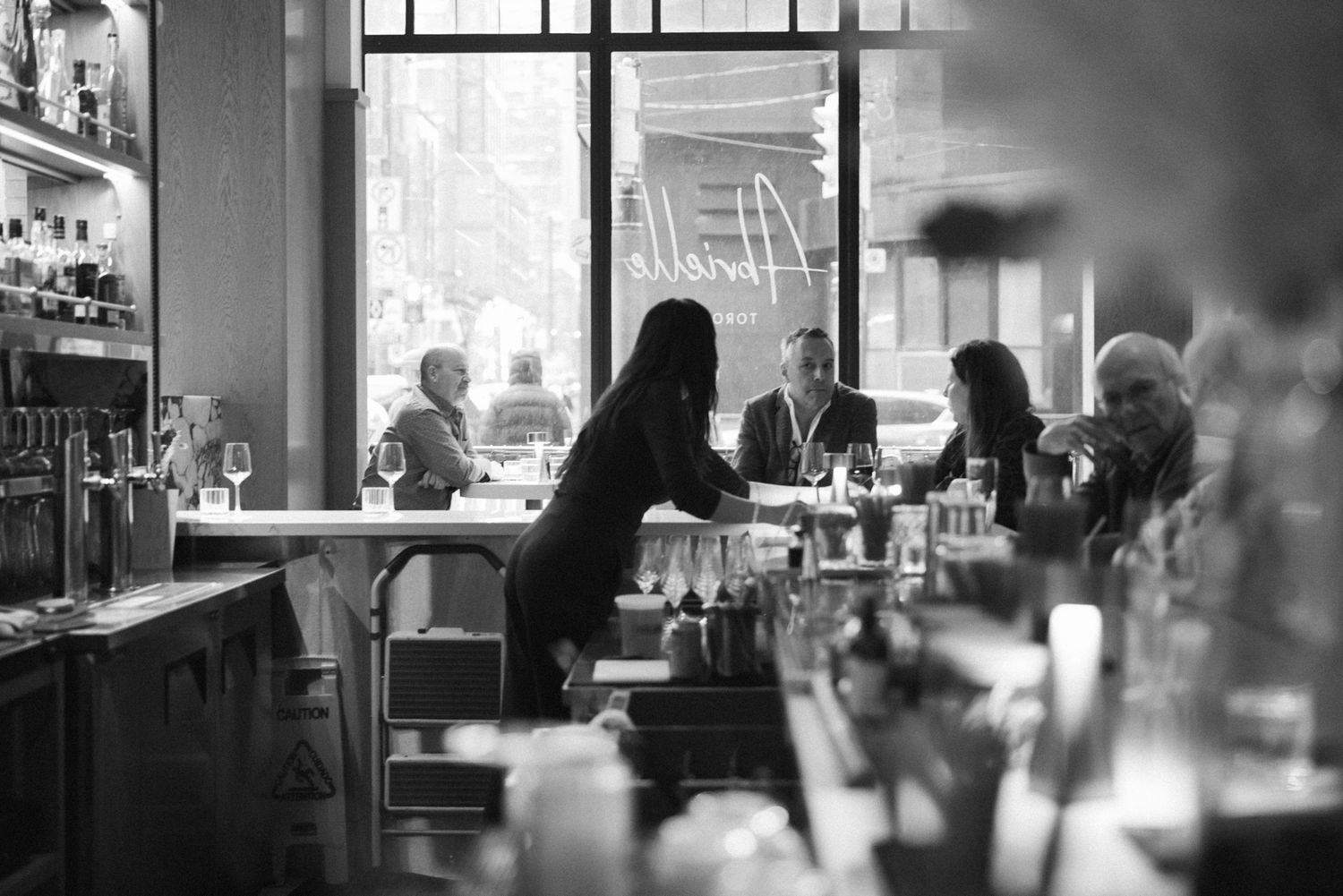 black and white photo of a bartender at Abrielle restaurant in Toronto, documentary style restaurant photography