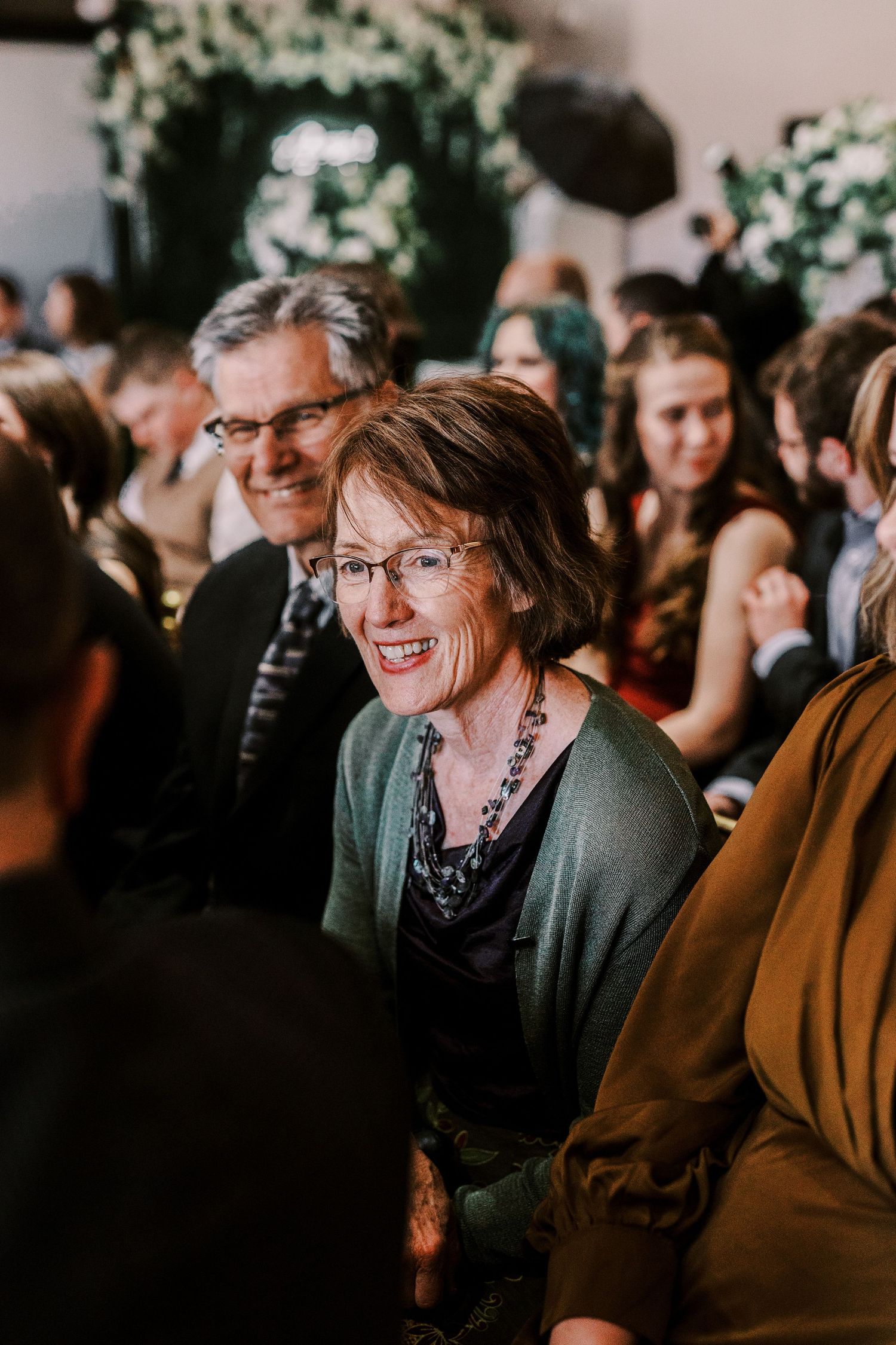 A crowd of people enjoying themselves at an indoor evening event or gathering.