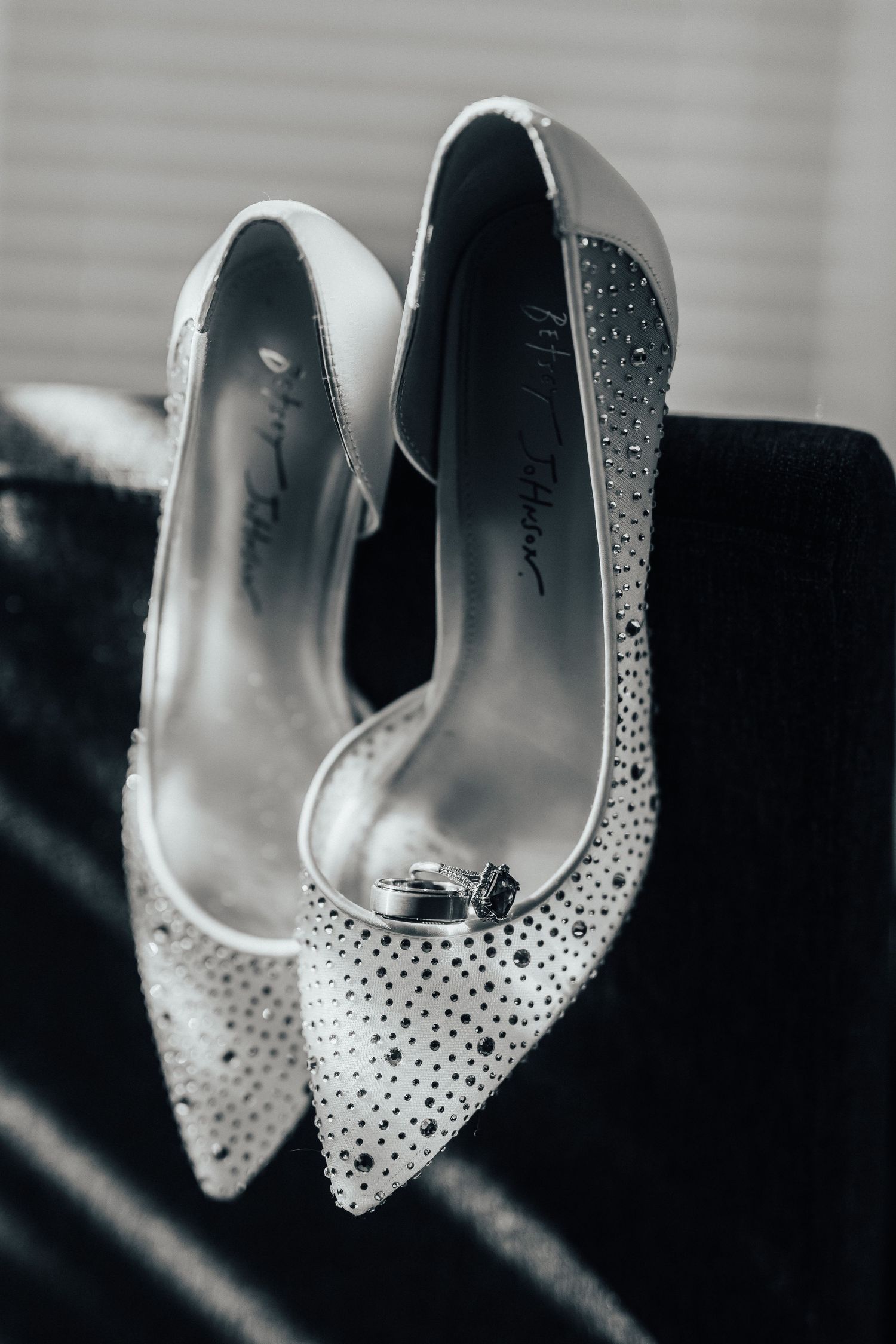 Elegant crystal-studded white high heel shoes with pointed toes and delicate rhinestone embellishments sparkle in black and white.