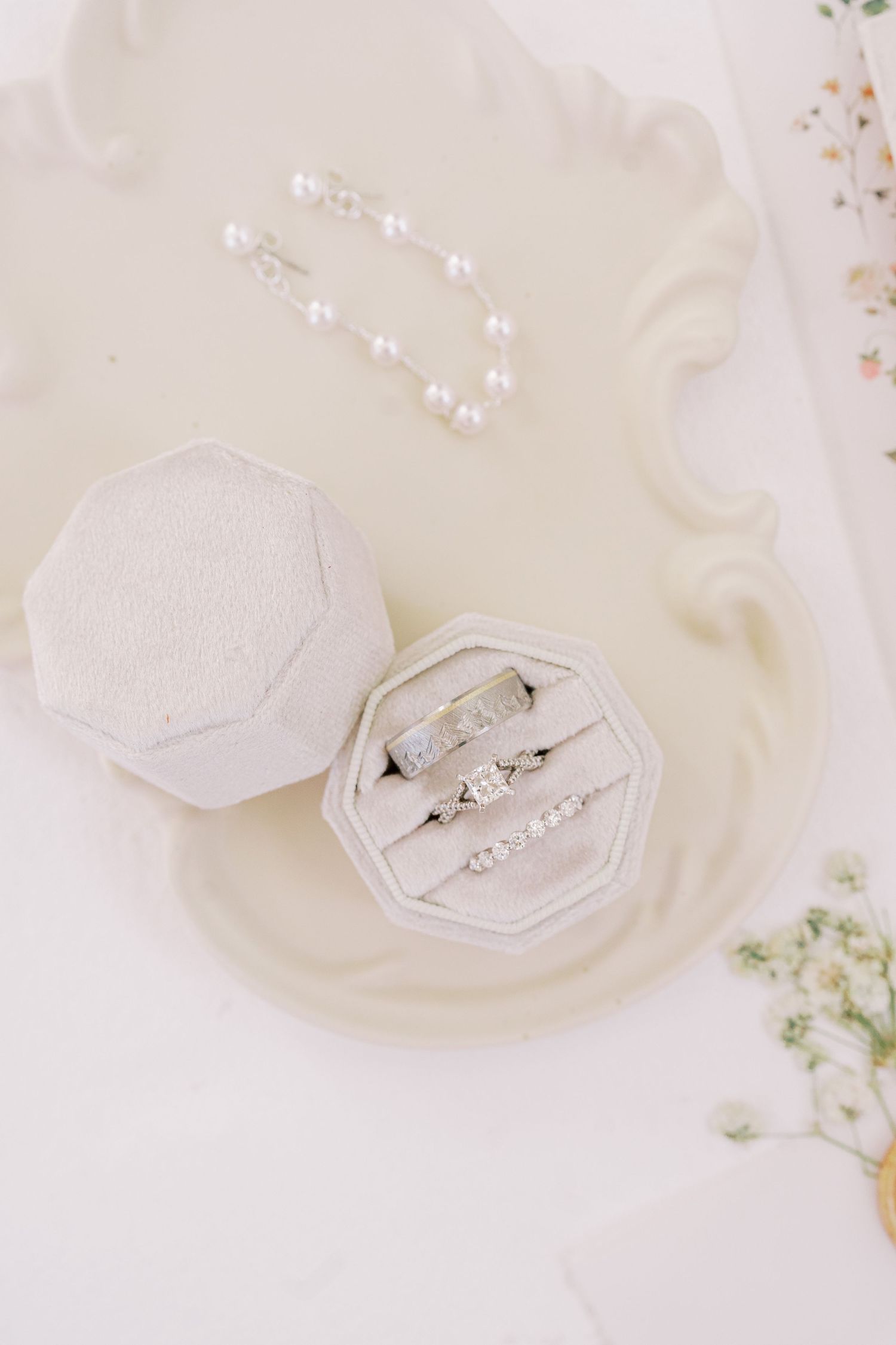 Elegant engagement ring displayed on white silk fabric with delicate floral accents in multiple artistic angles.
