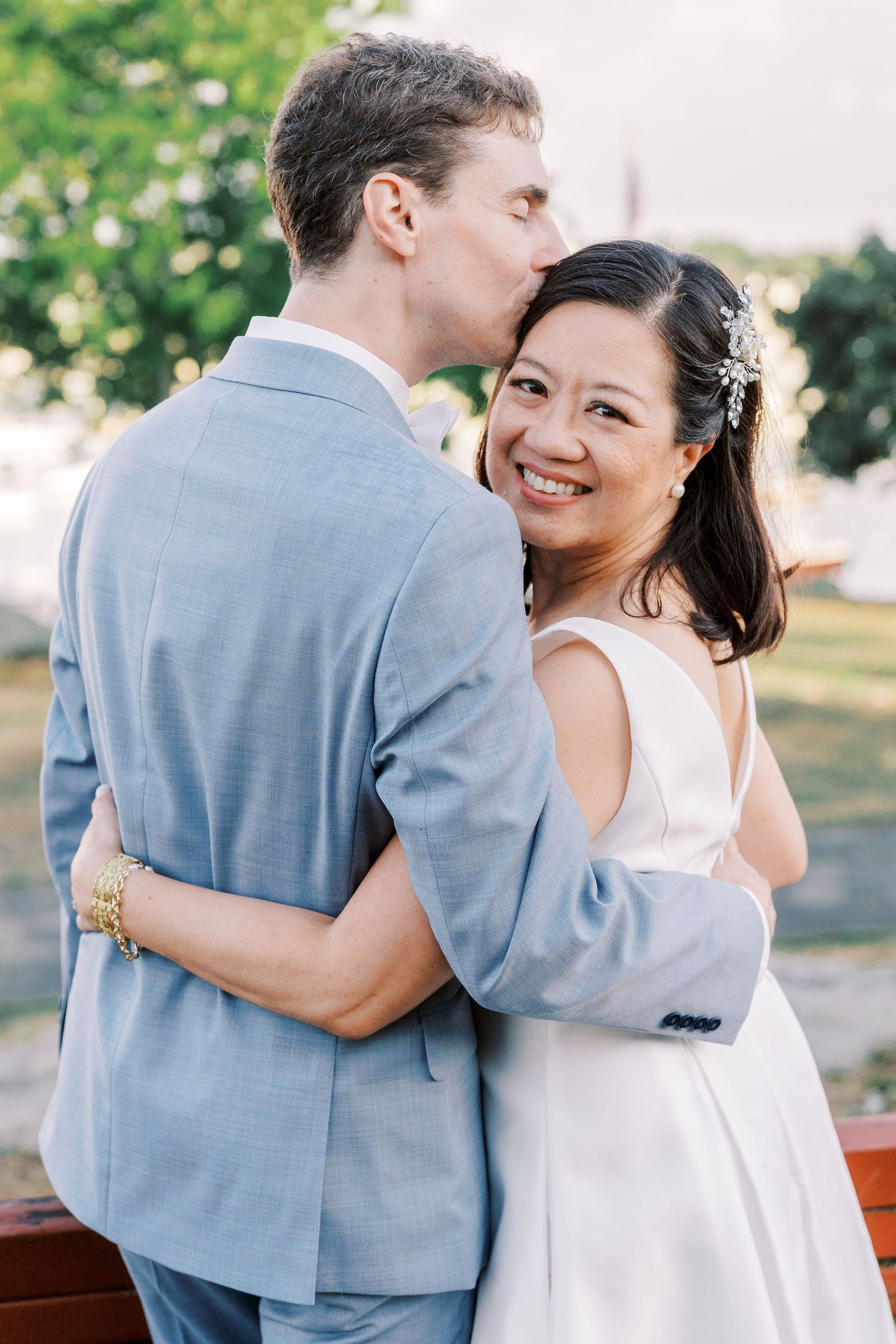 A joyful moment captured between a couple in light blue and white attire at their wedding celebration.