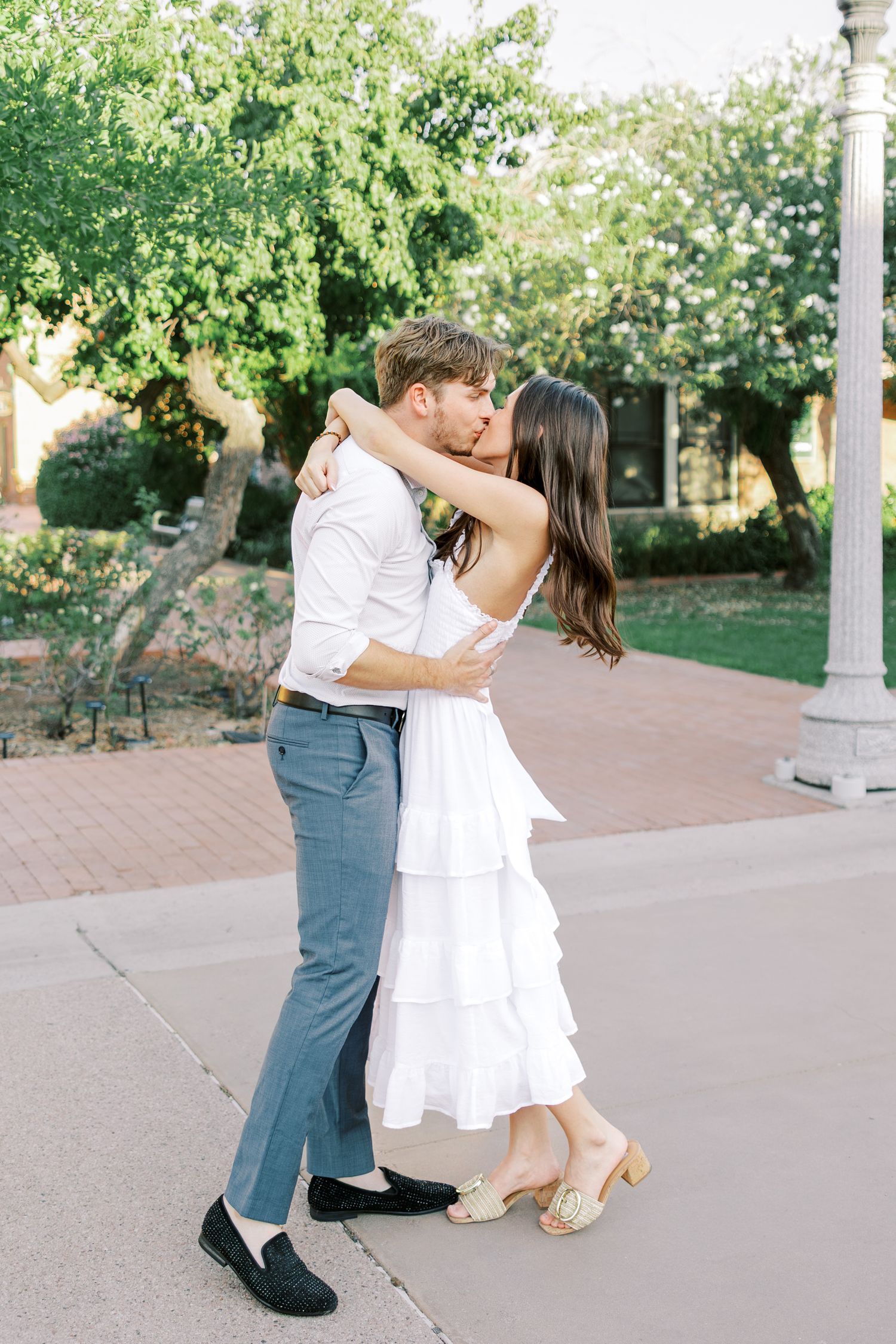 Dancing couple in coordinated outfits spinning together on a paved outdoor pathway.