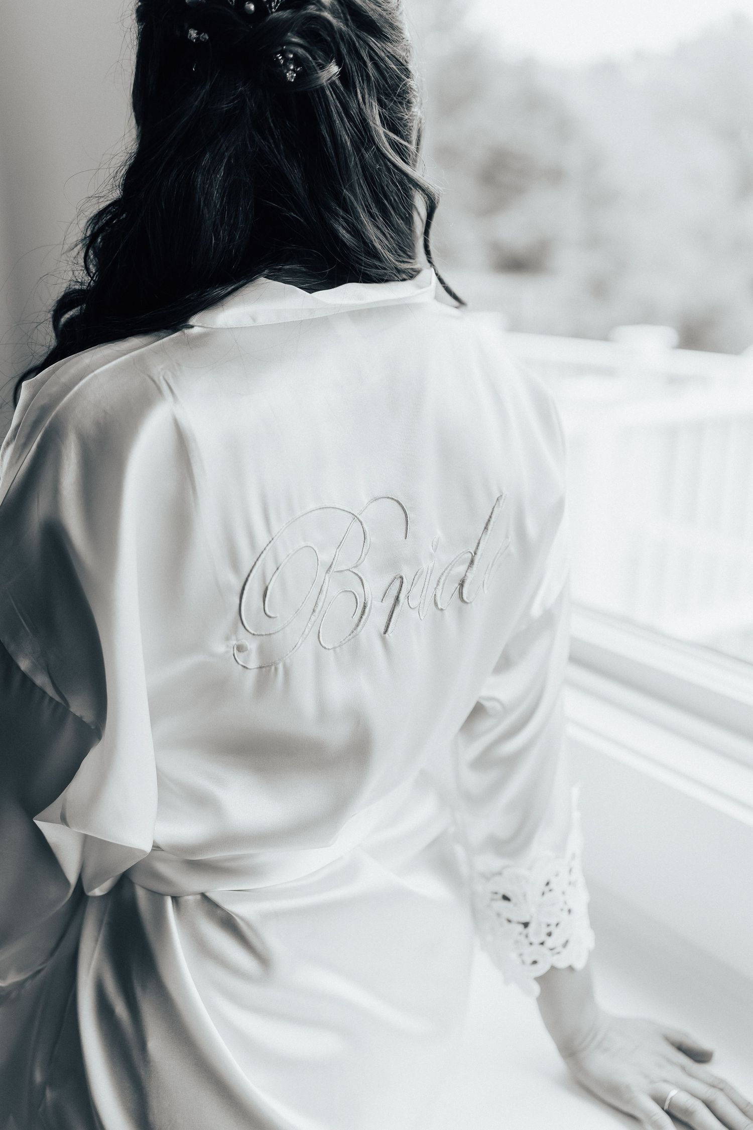 White silk bridal robe with embroidered 'Bride' text detail in monochrome.