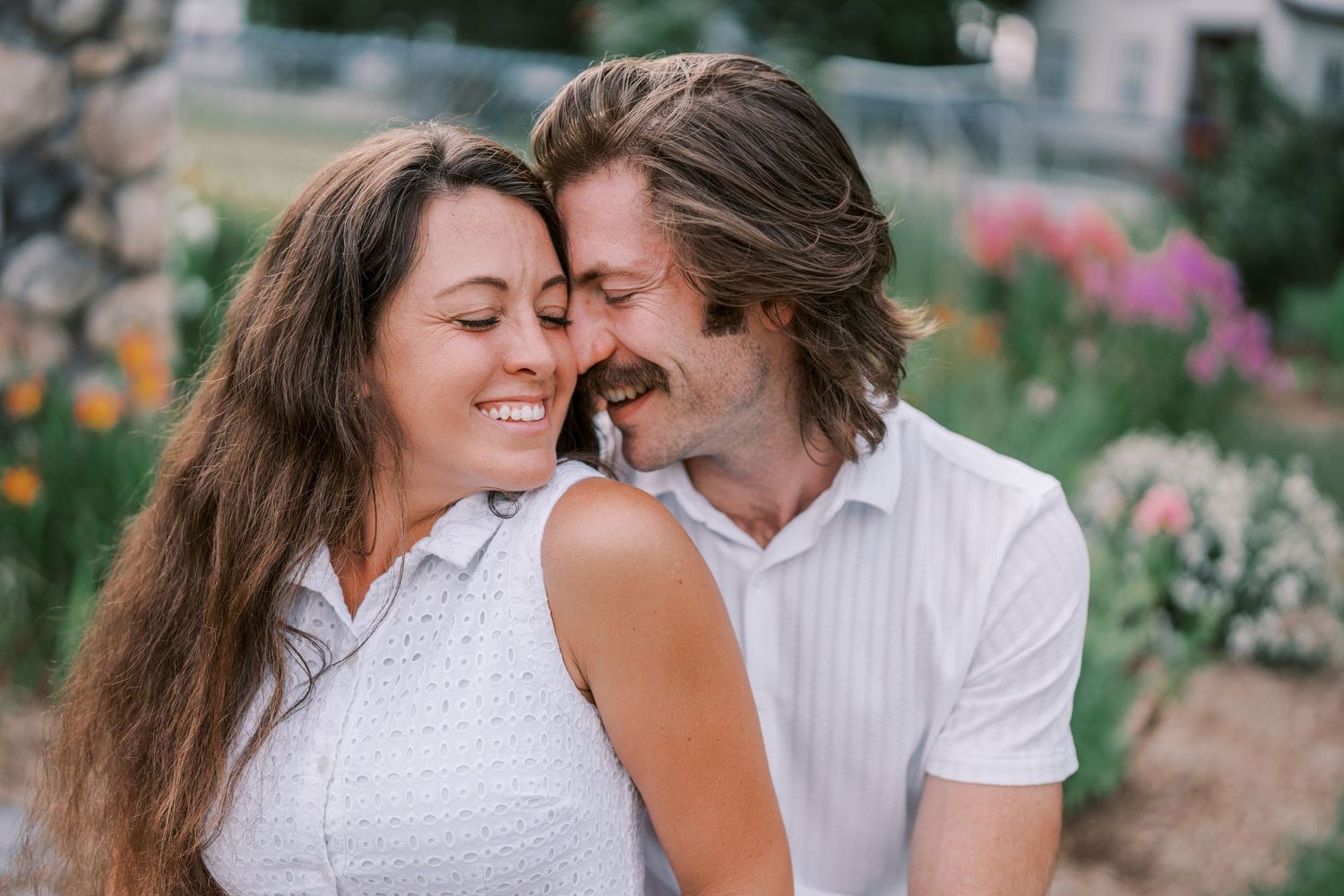 A couple enjoys a tender moment together in an outdoor setting.