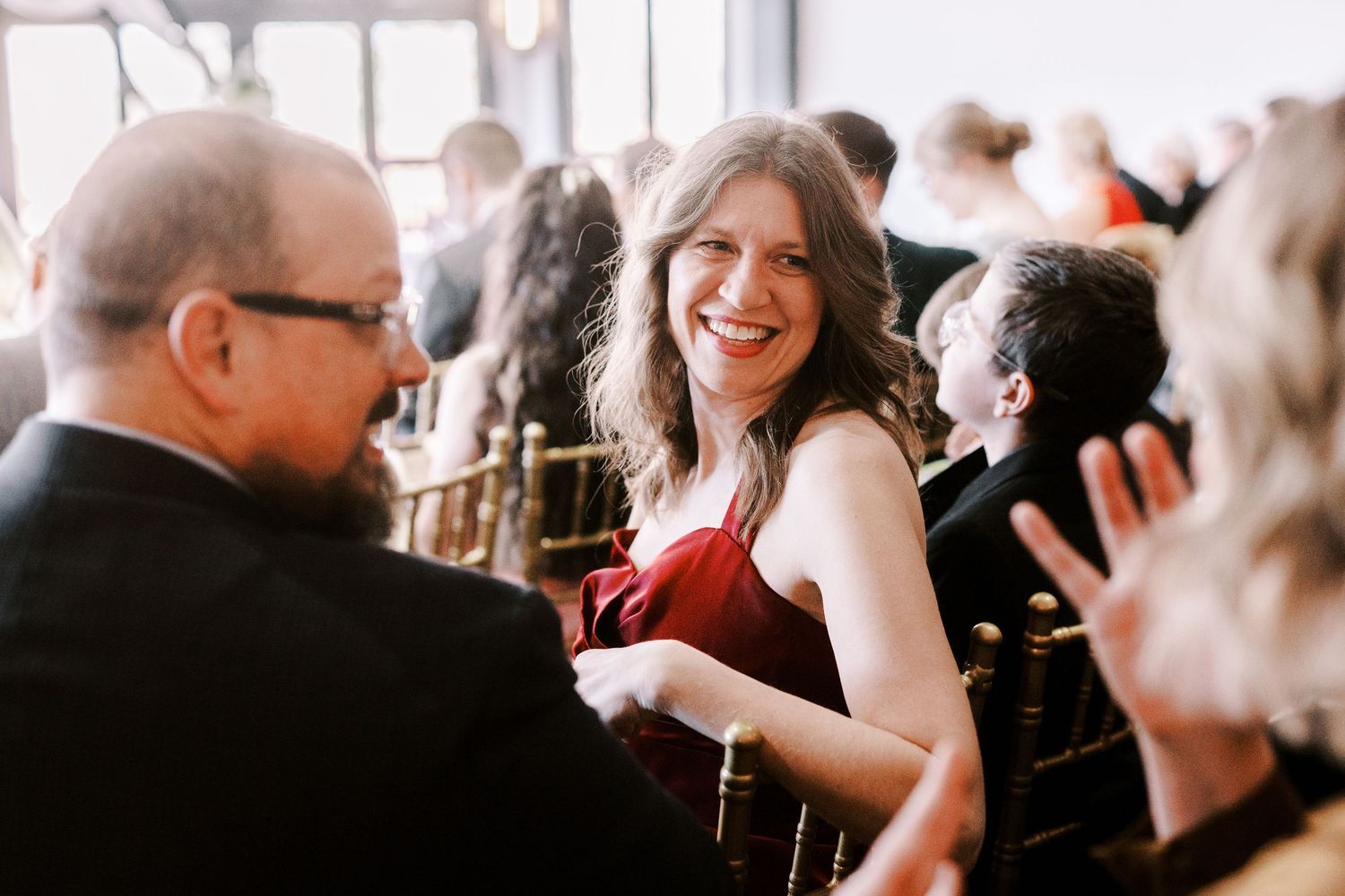Wedding reception guests sharing laughter and joy during celebration.