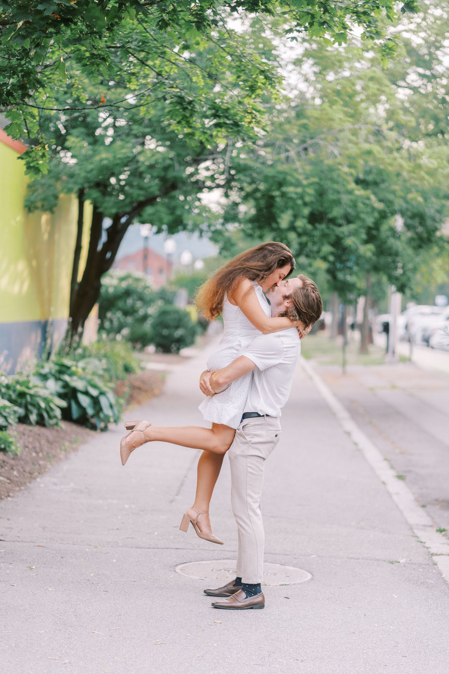 A playful moment captured on a tree-lined path with summer greenery.